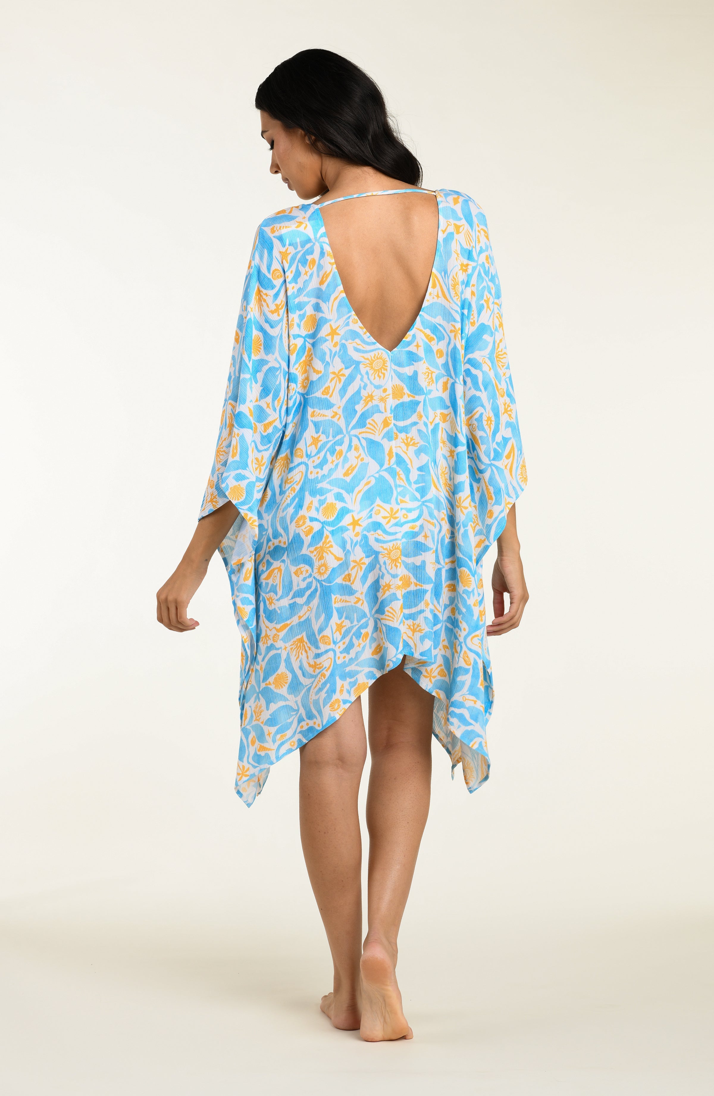 Woman wearing a blue floral kimono cover-up on a white background