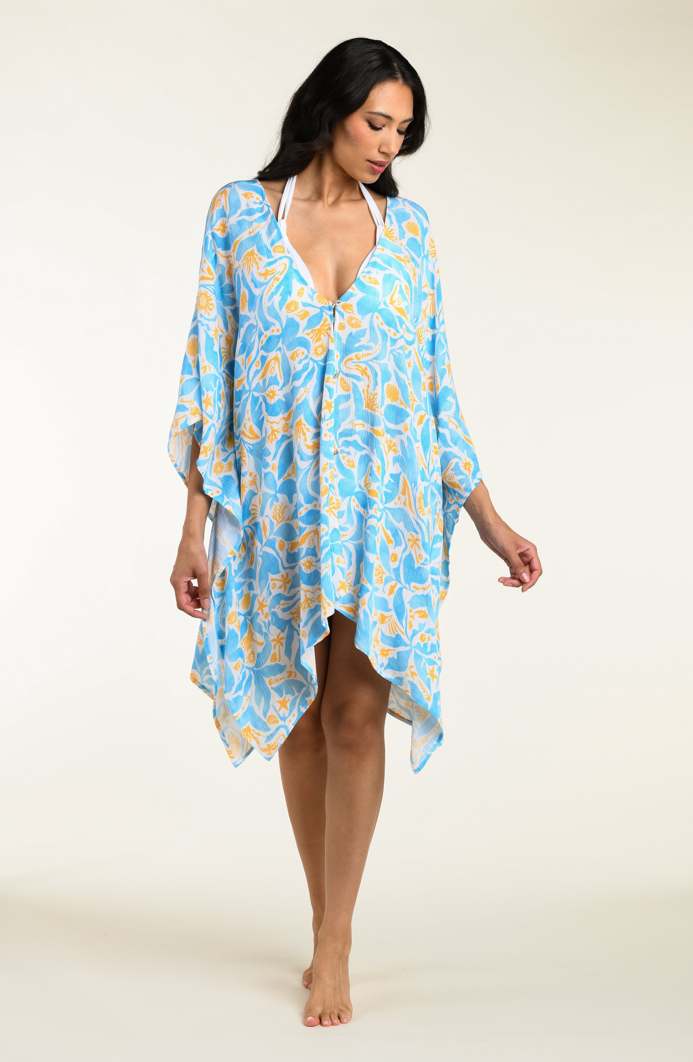 Woman wearing a blue floral kimono cover-up on a white background