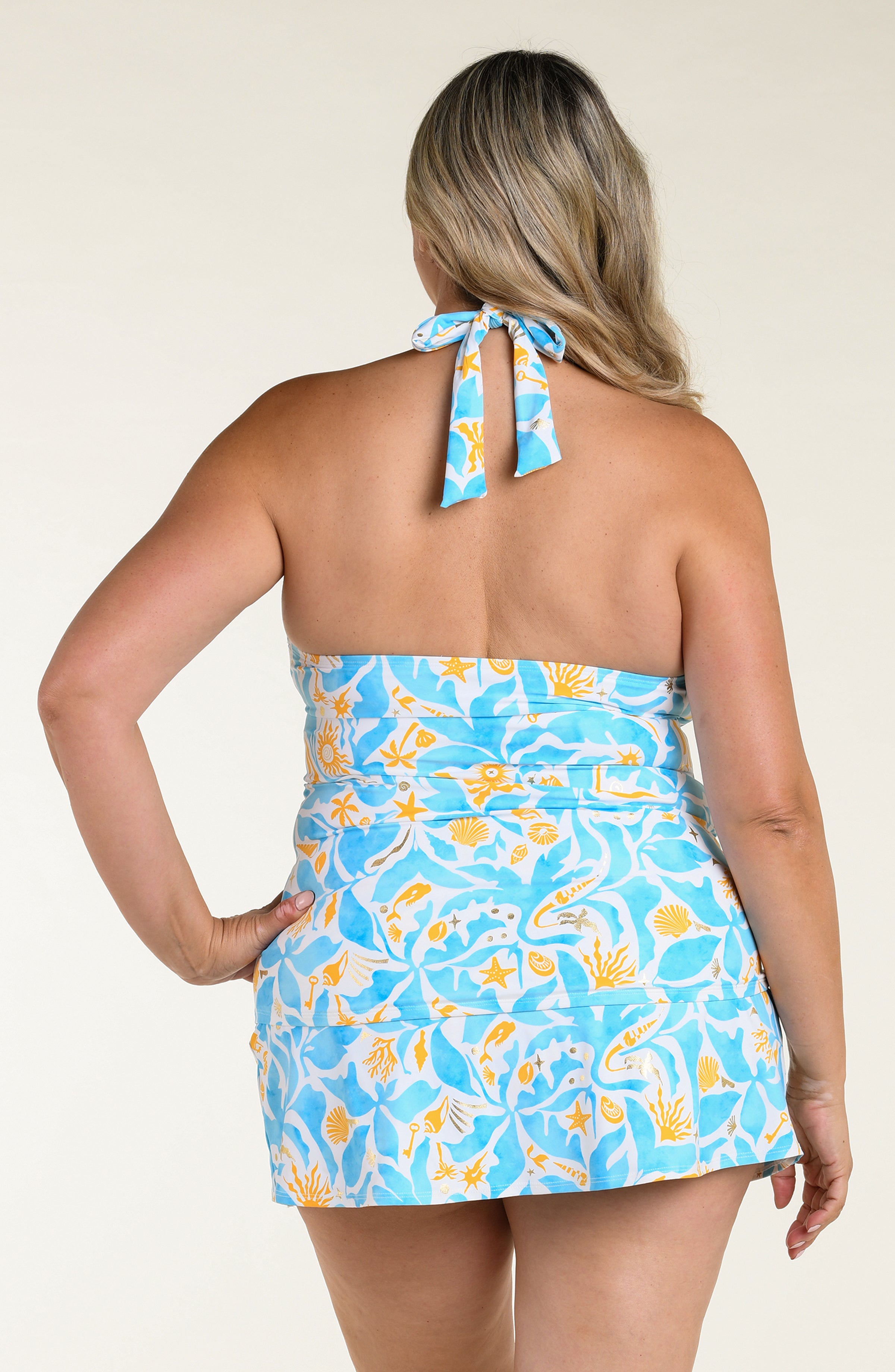 Woman wearing a blue multicolored tankini top and matching swim skirt on a white background