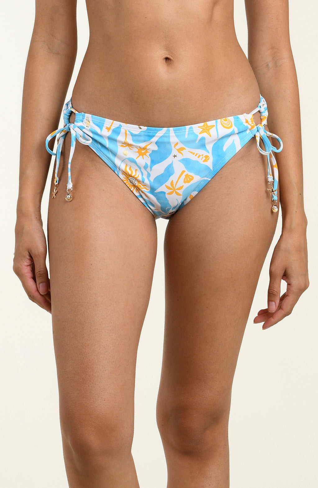 Woman wearing a multicolored blue and white bikini bottom against a white background. 