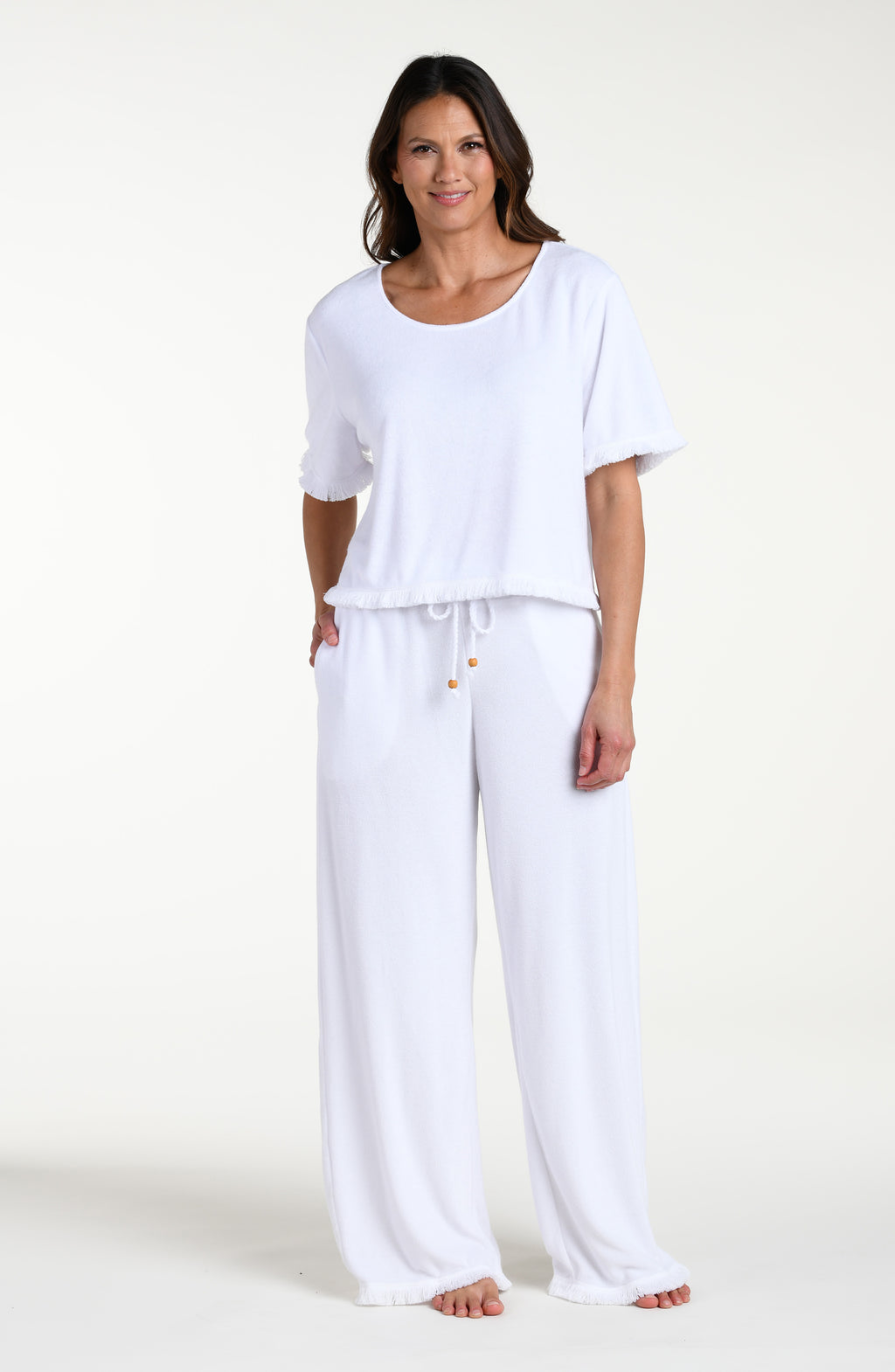 Woman wearing a white short sleeve top and matching pants against a white background