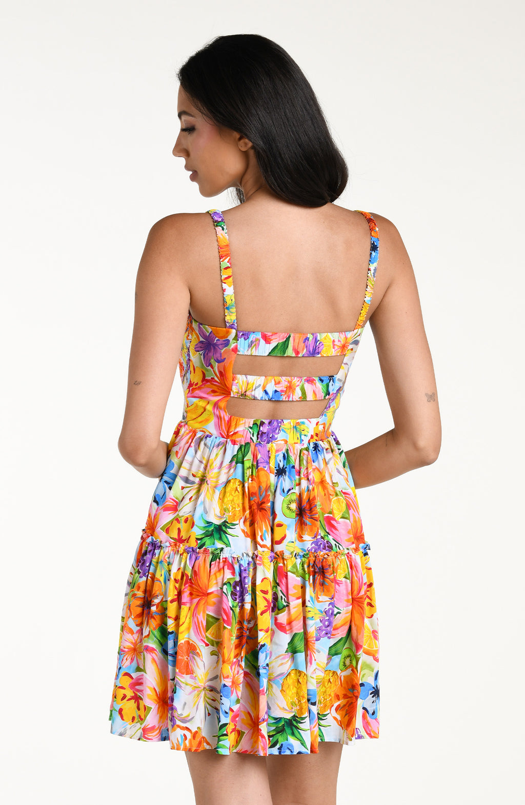 Woman wearing a colorful floral mini dress cover up against a white background