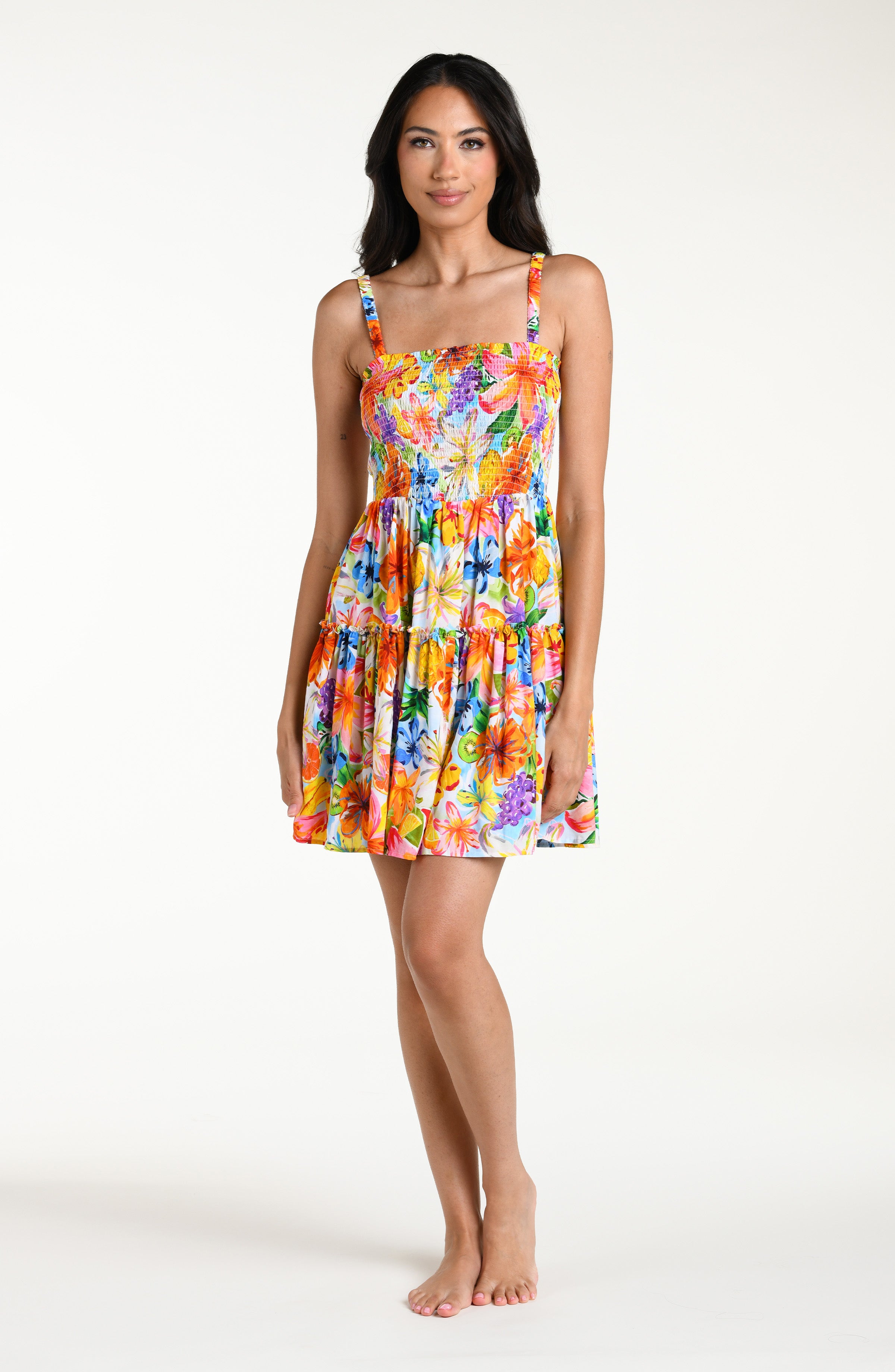 Woman wearing a colorful floral mini dress cover up against a white background