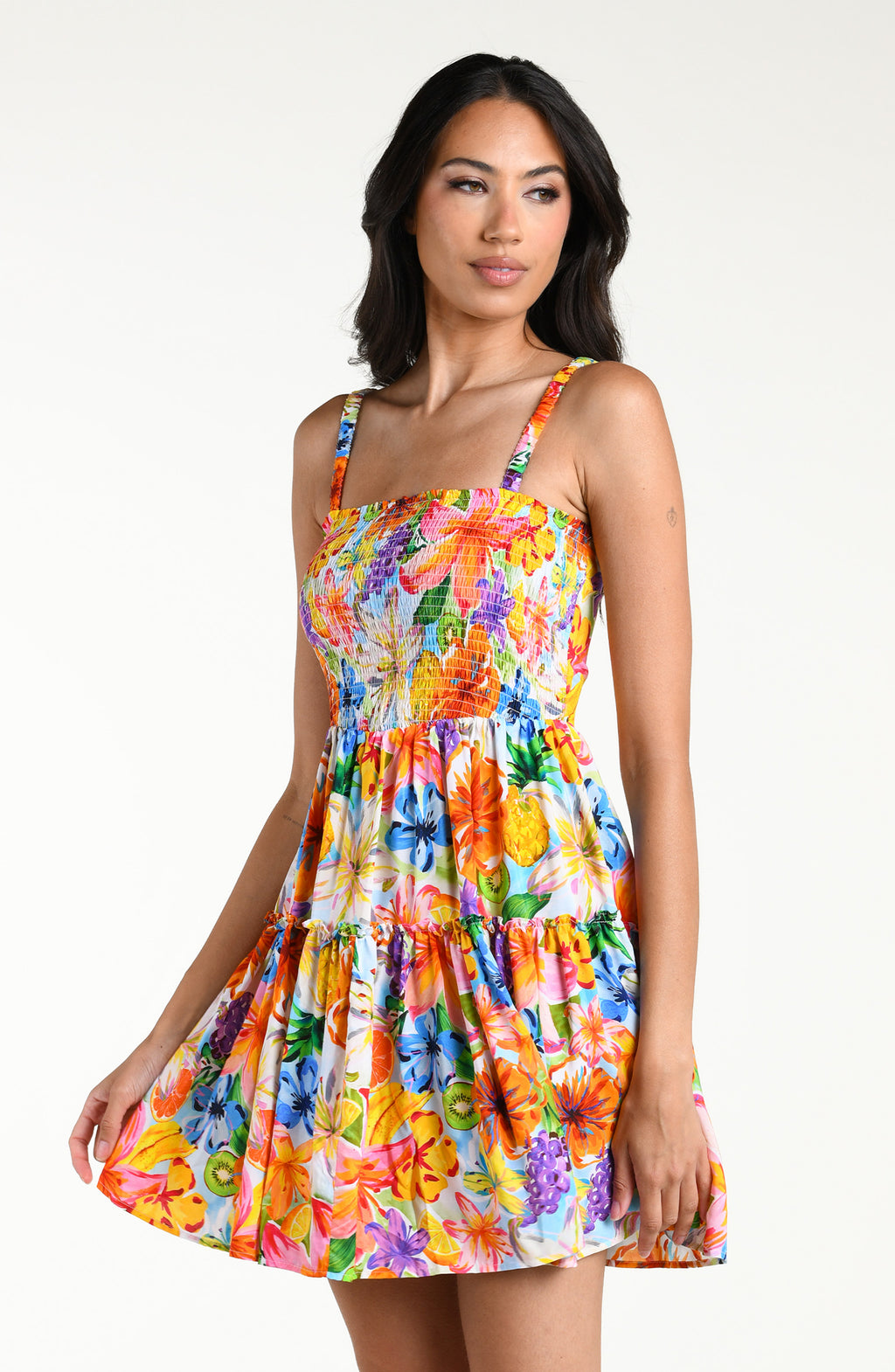 Woman wearing a colorful floral mini dress cover up against a white background