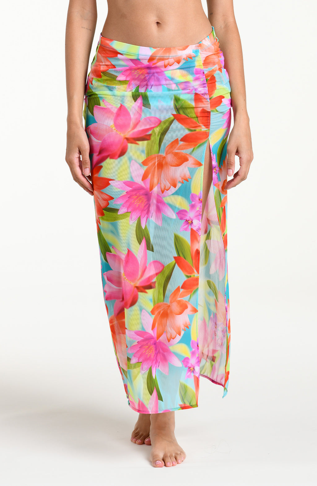 Woman wearing a bright floral midi skirt cover up against a white background