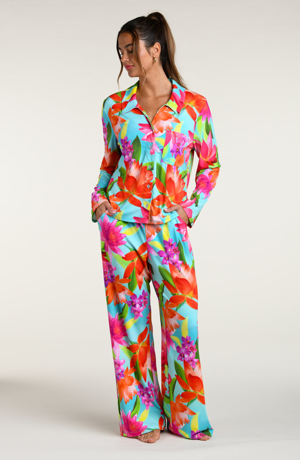 Woman wearing a colorful floral pajama pant set against a white background