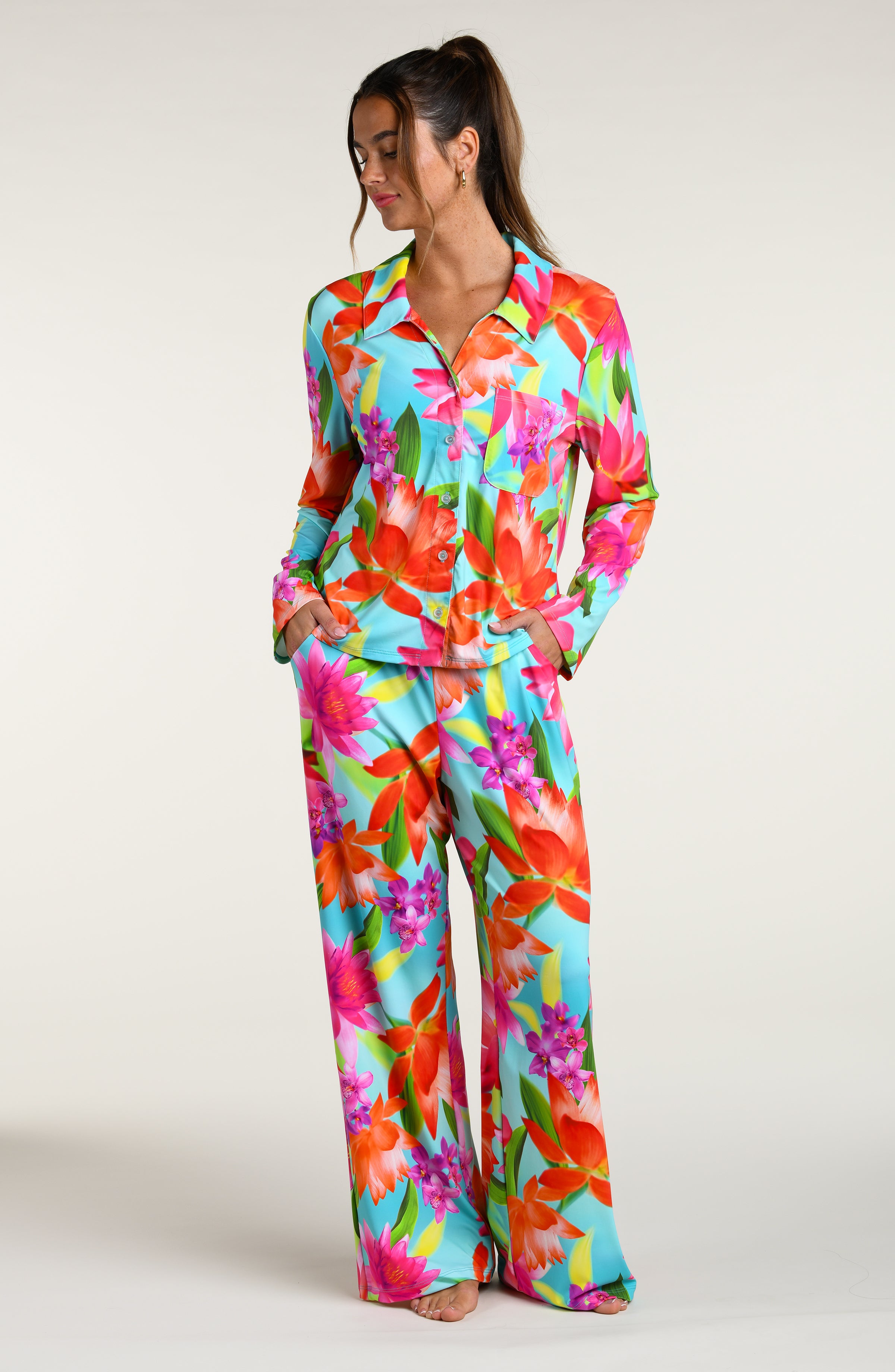 Woman wearing a colorful floral pajama pant set against a white background