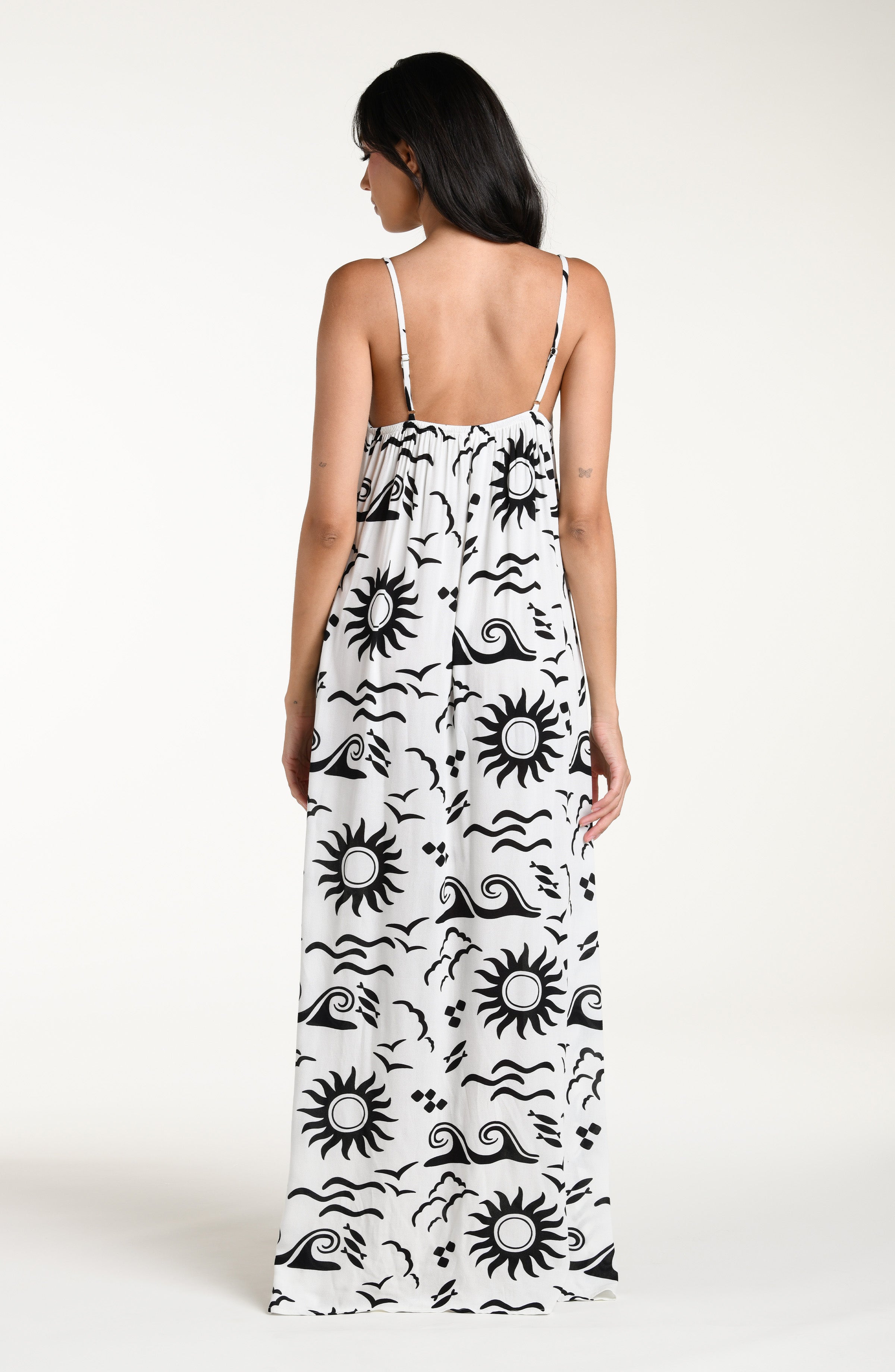Woman wearing a black and white patterned maxi dress against a white background