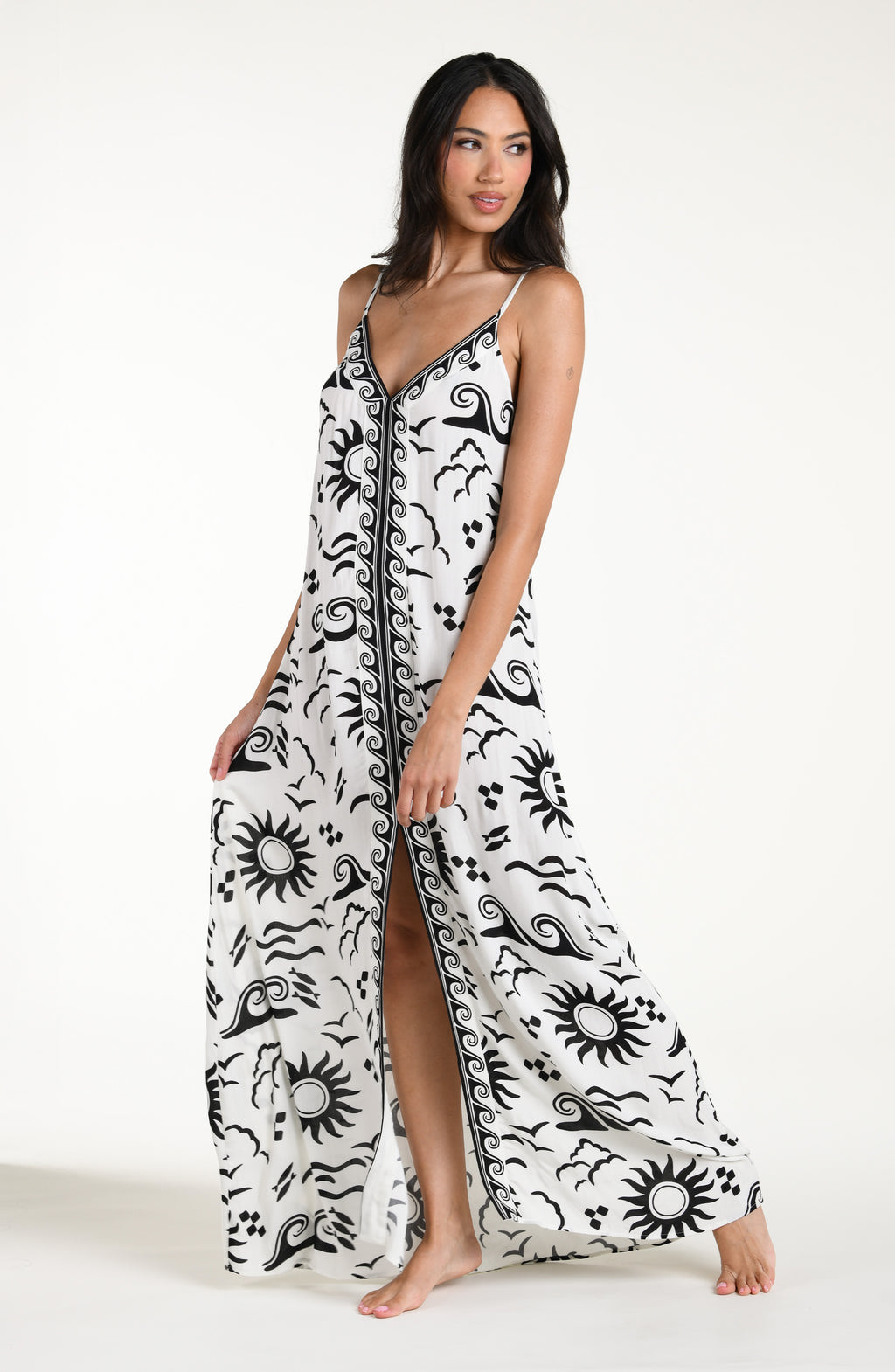 Woman wearing a black and white patterned maxi dress against a white background