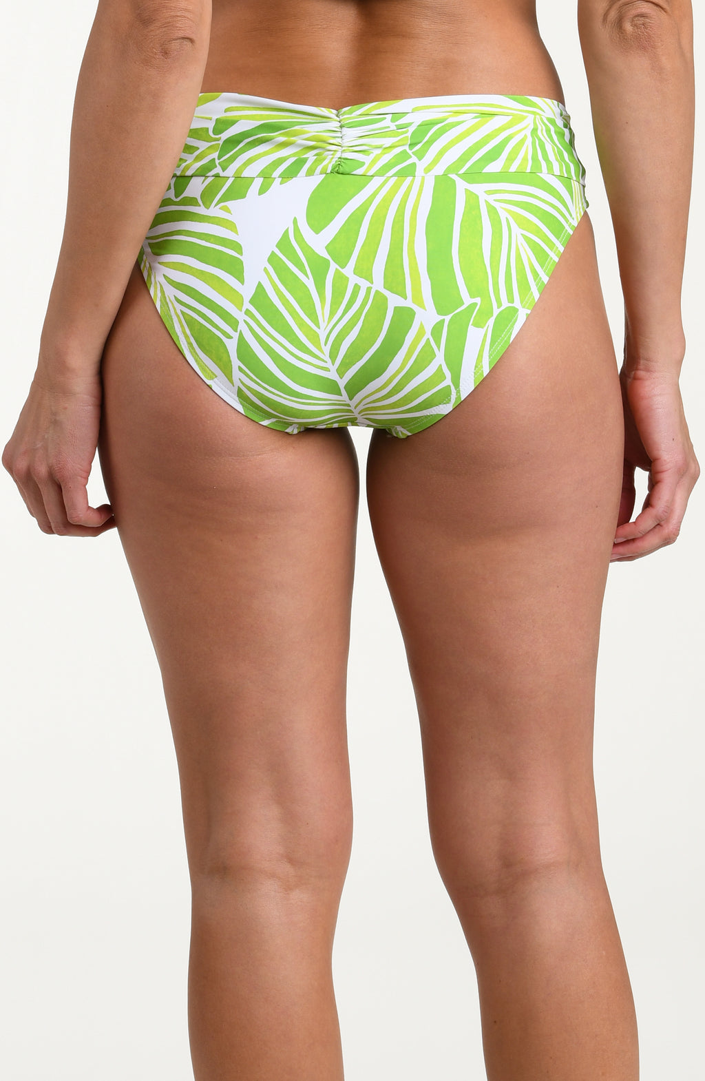 Woman wearing a green and white patterned bikini bottom on a white background