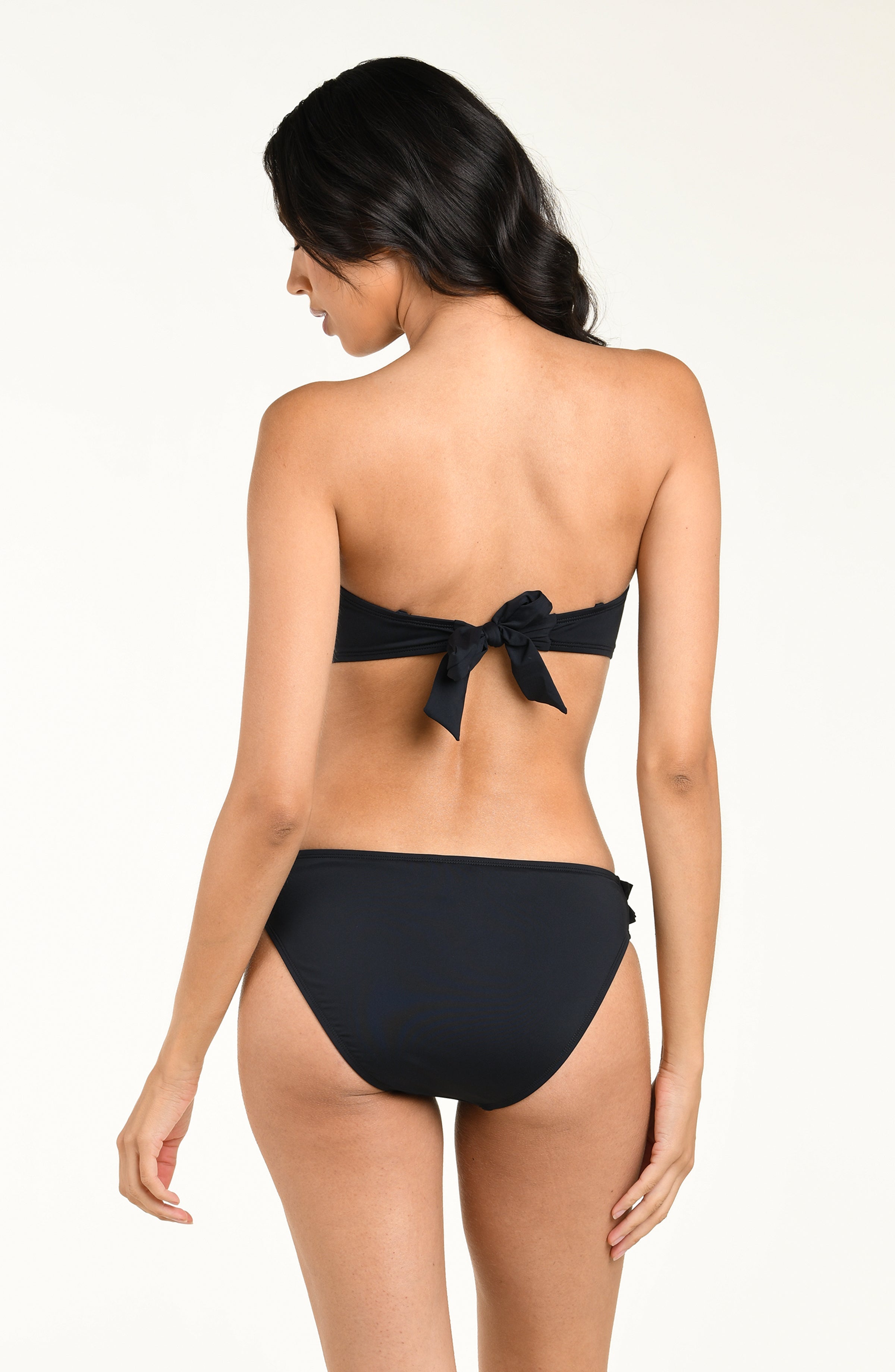 Woman wearing a black bikini top with floral details and a matching bikini top on a white background