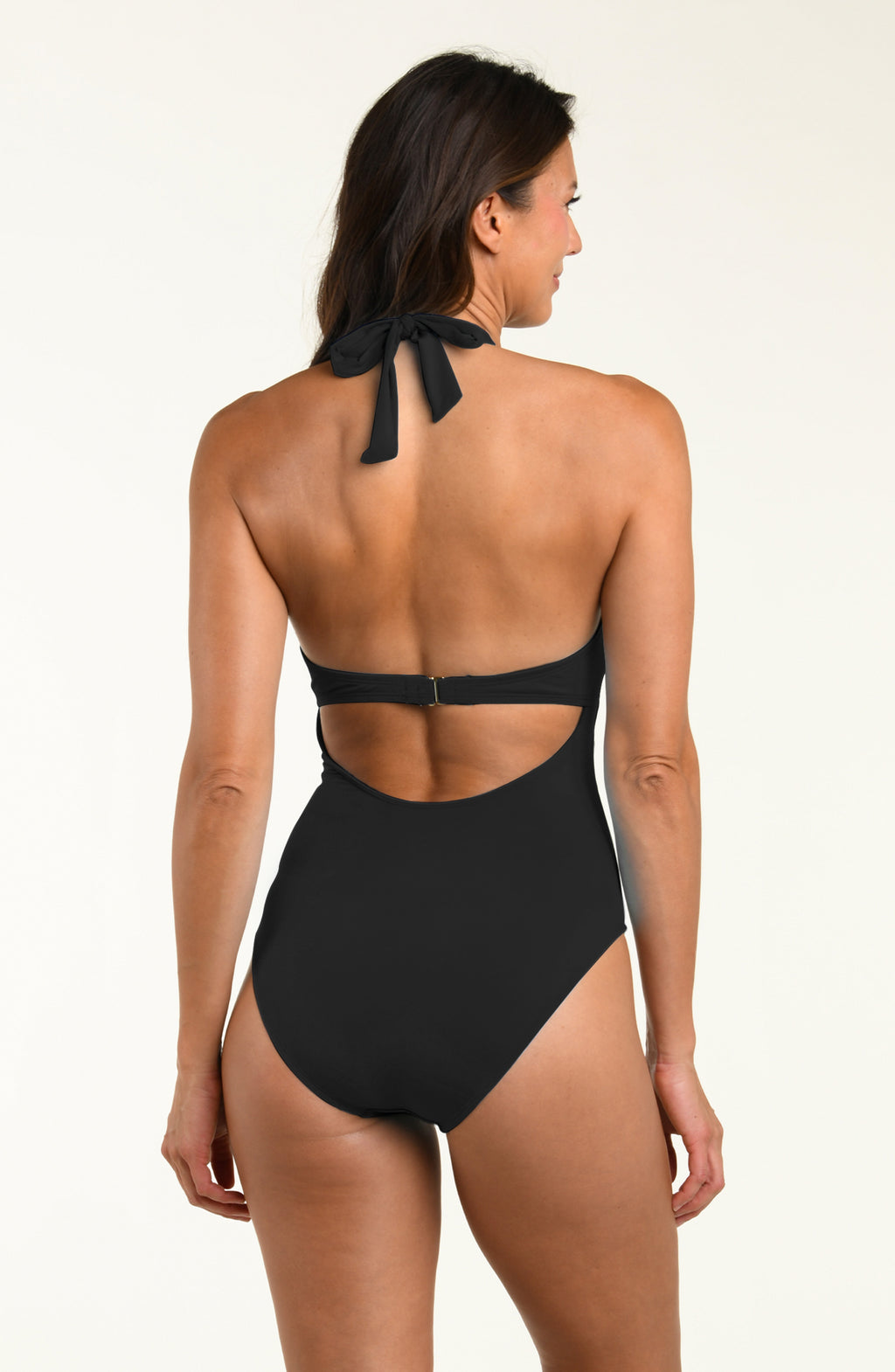 Woman wearing a black one piece swimsuit against a white background.