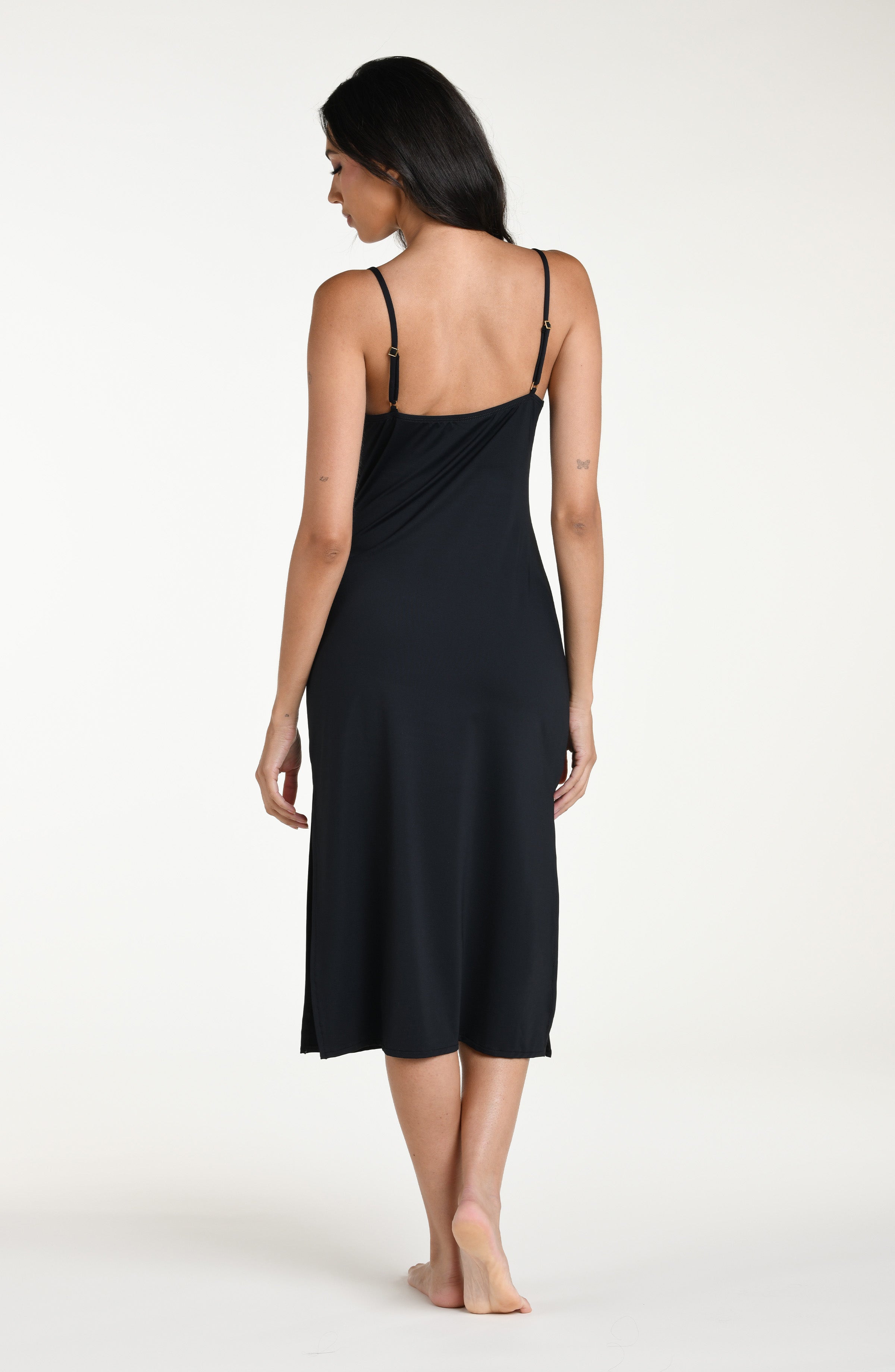 Woman wearing a black midi dress against a white background