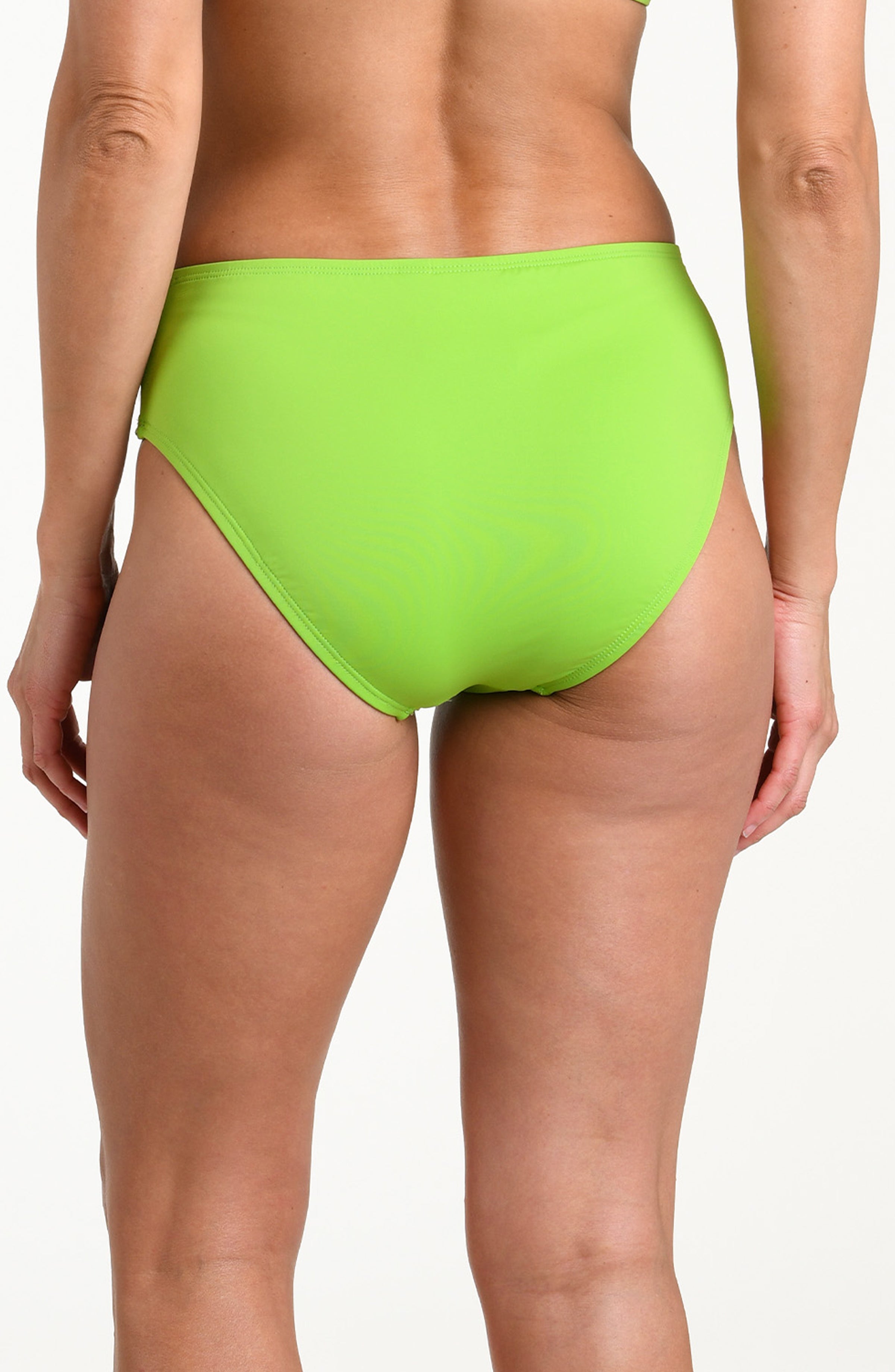 Woman wearing an apple green mid waist bottom against a white background.