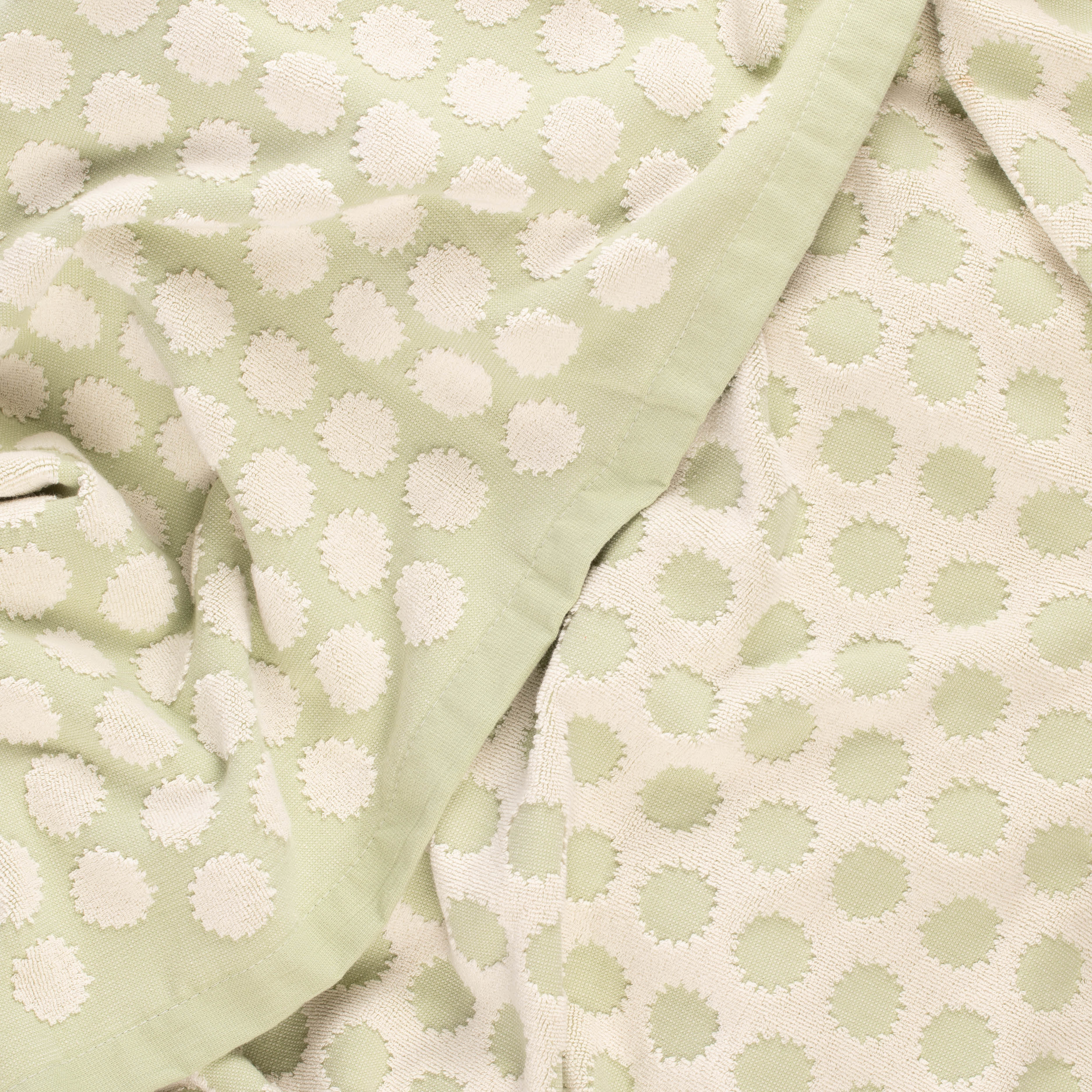 Close-up of a light green beach towel with design by Layday