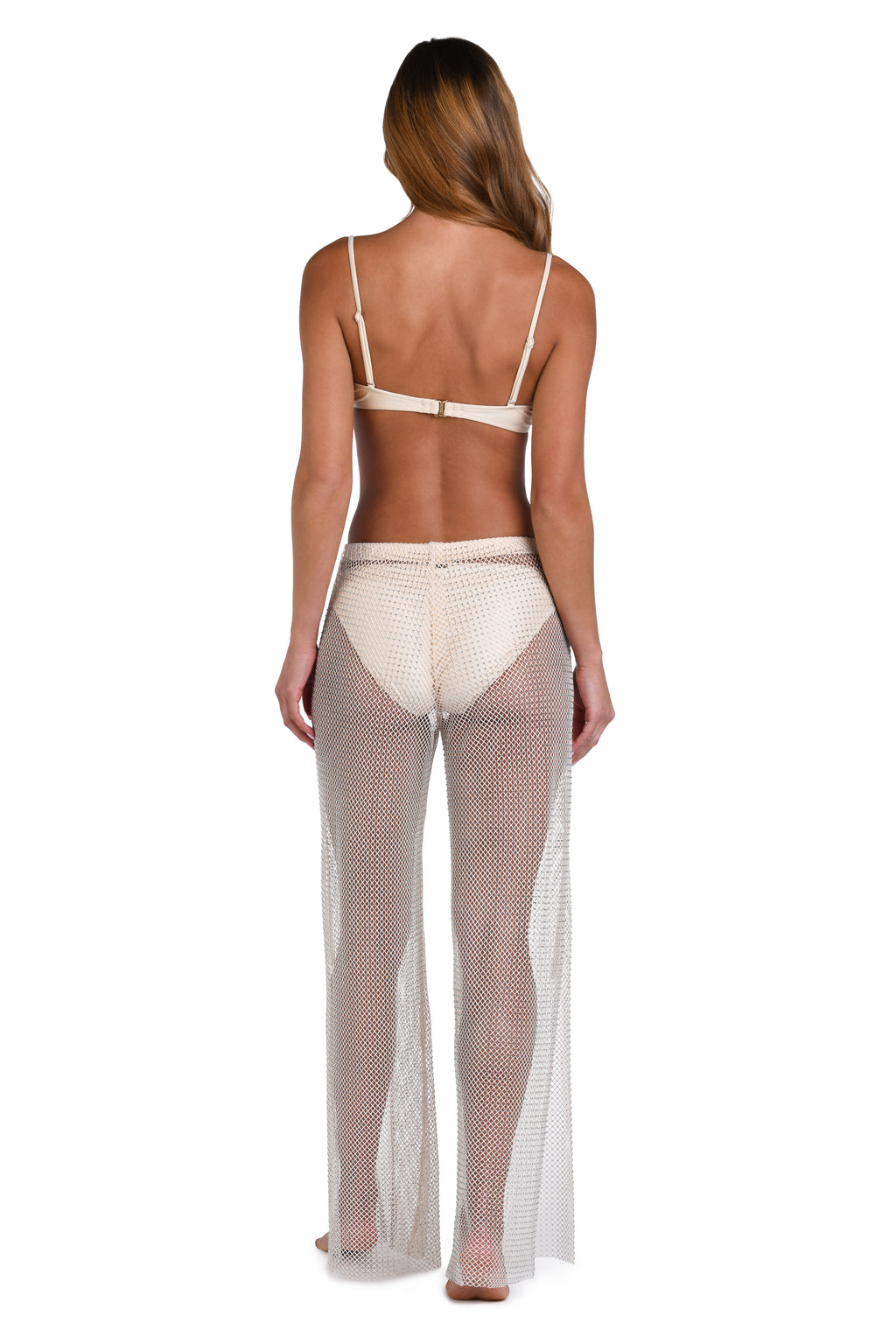 A woman shown from the back wearing a sheer, open-knit beige maxi cover-up over a light beige bikini, set against a plain white background.