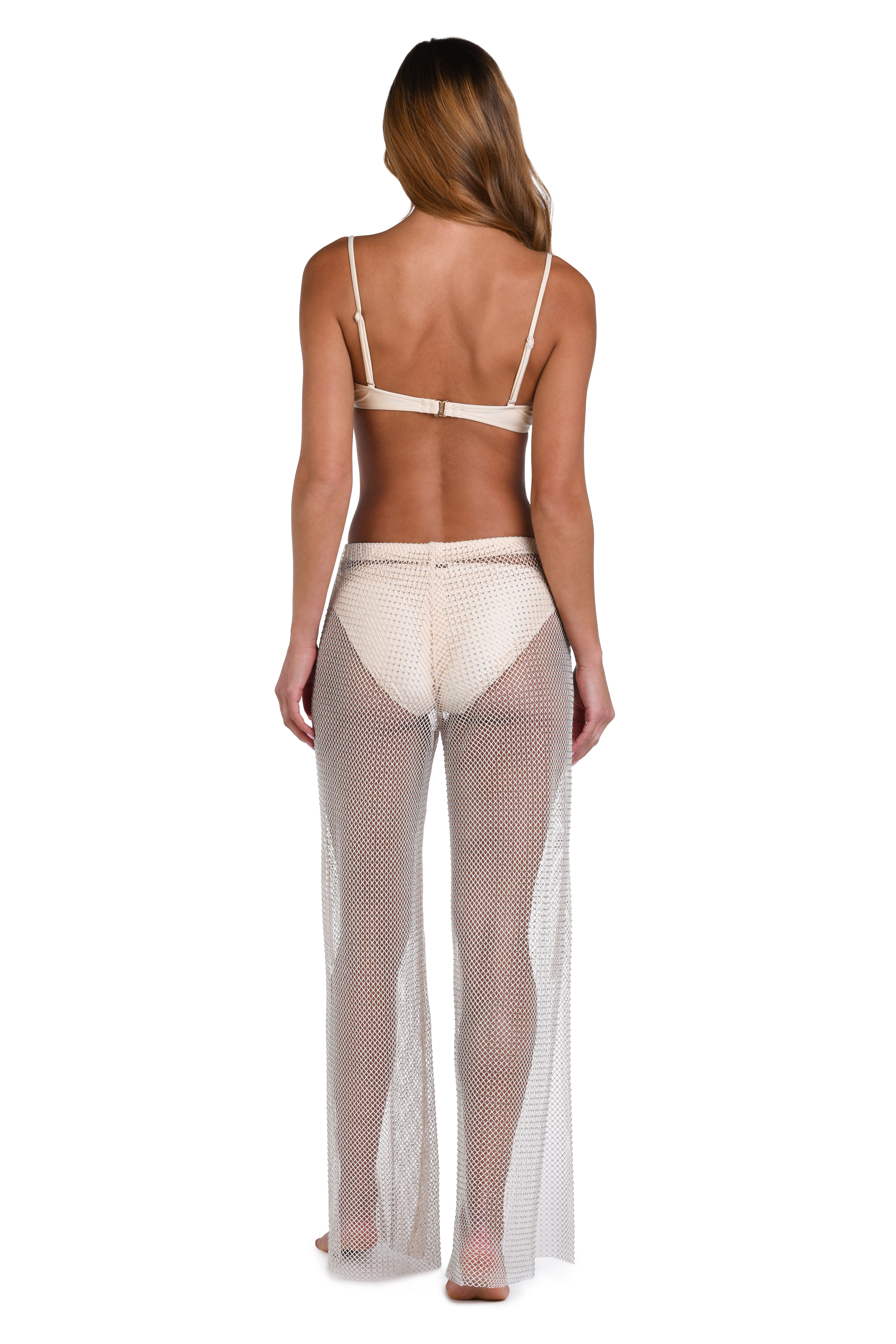 A woman shown from the back wearing a sheer, open-knit beige maxi cover-up over a light beige bikini, set against a plain white background.