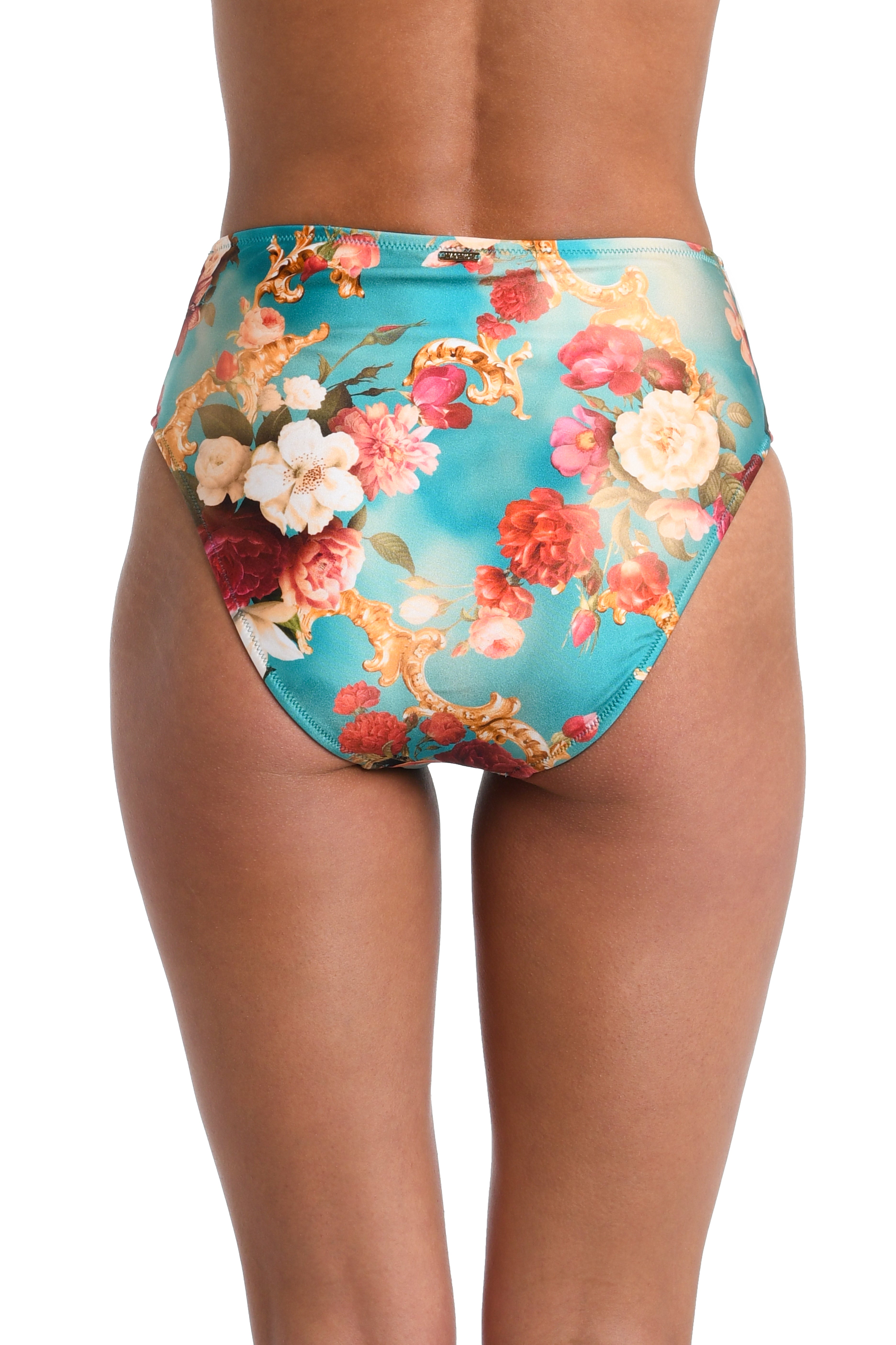 Rear view of a model wearing high-waisted bikini bottoms with a turquoise blue background and a floral print in pink, red, white, and gold.