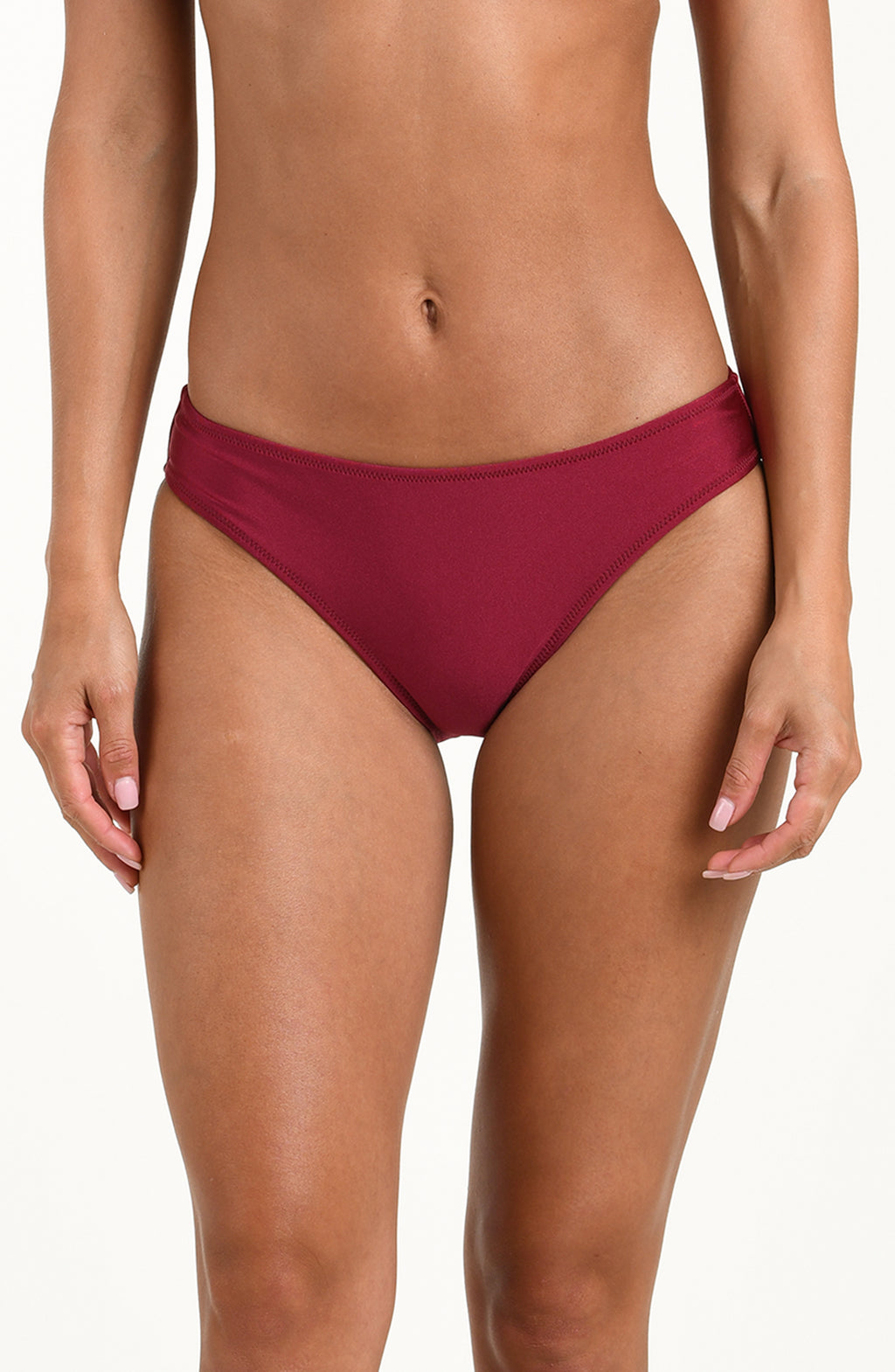 Woman wearing a black cherry bikini bottom against a white background. 