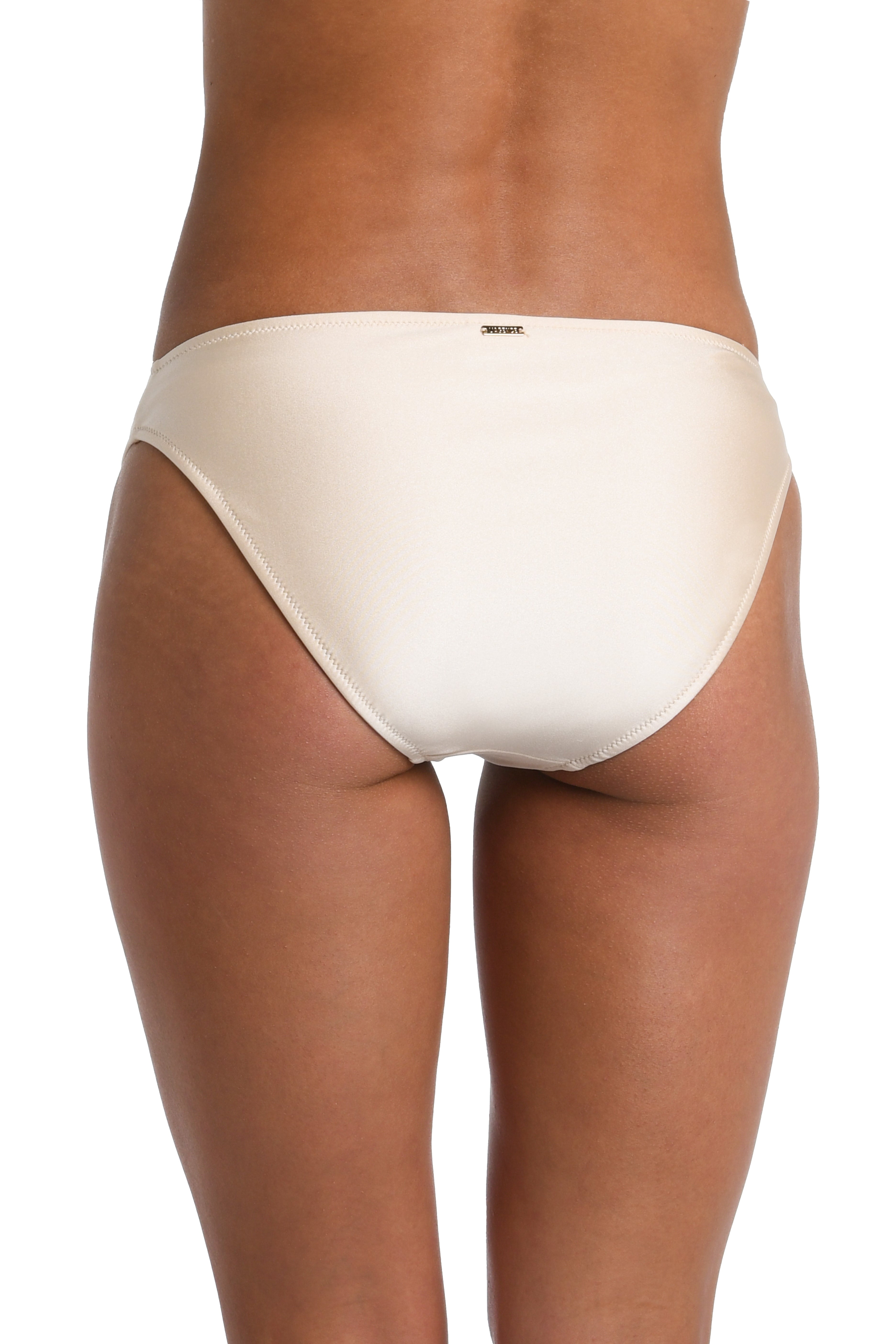 Woman wearing an ivory colored hipster bikini bottom against a white background. 