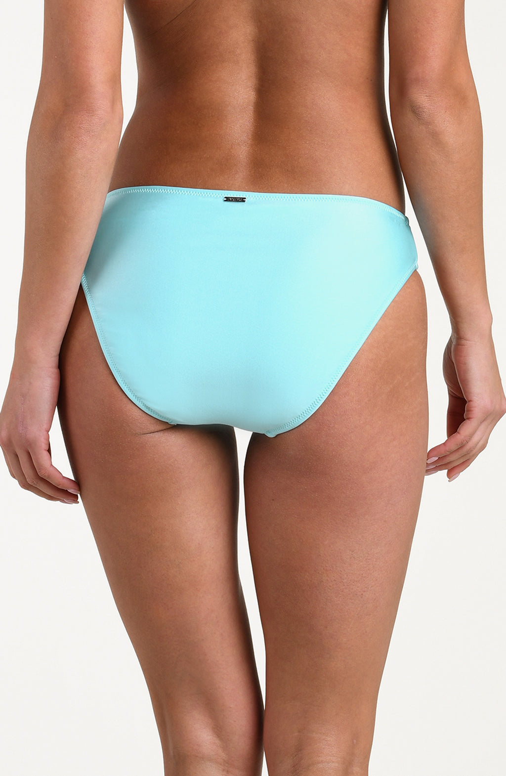 Woman wearing an aqua blue colored bikini bottom against a white background. 
