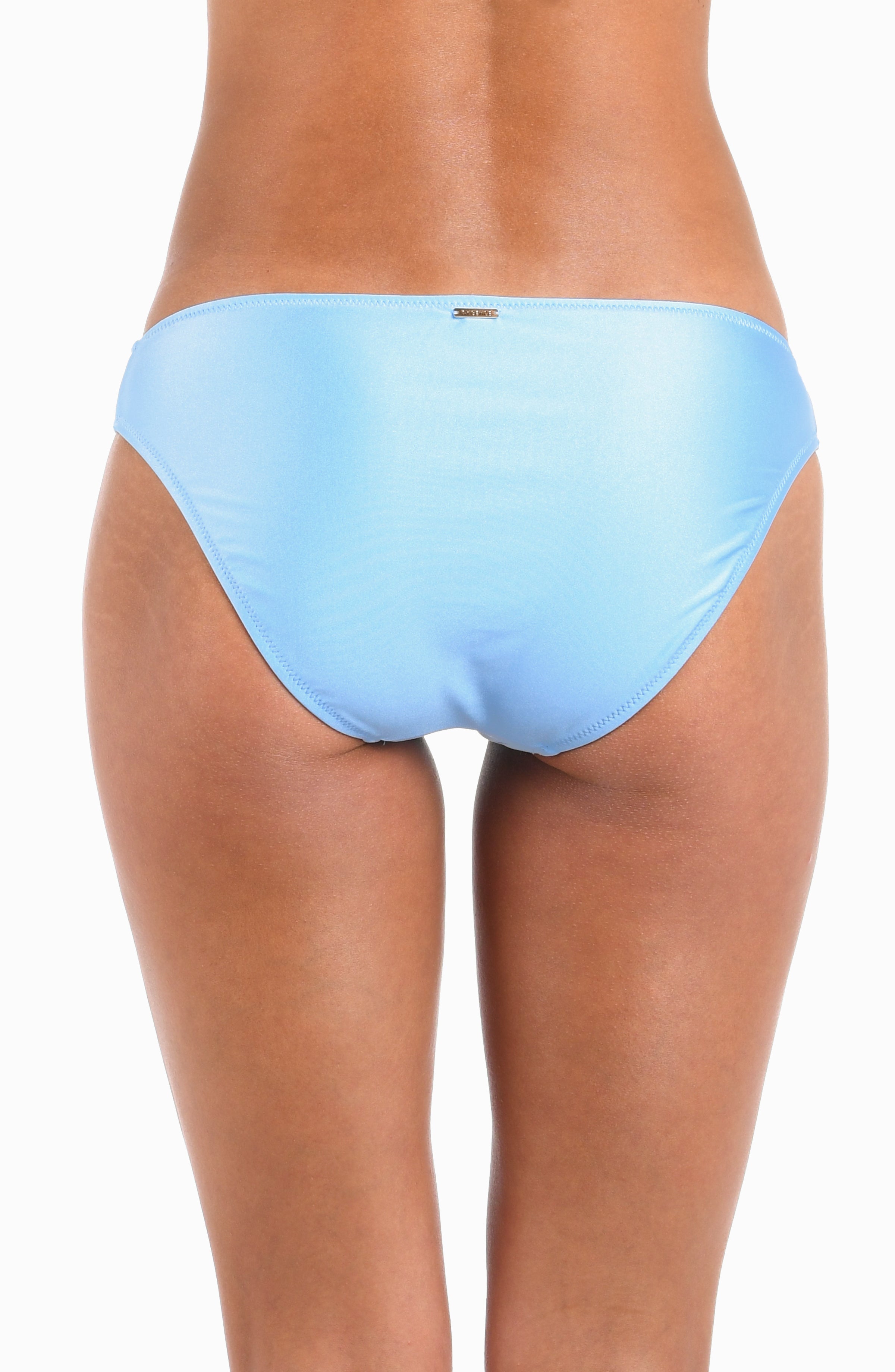 Rear view of a model wearing light blue bikini bottoms against a plain white background.