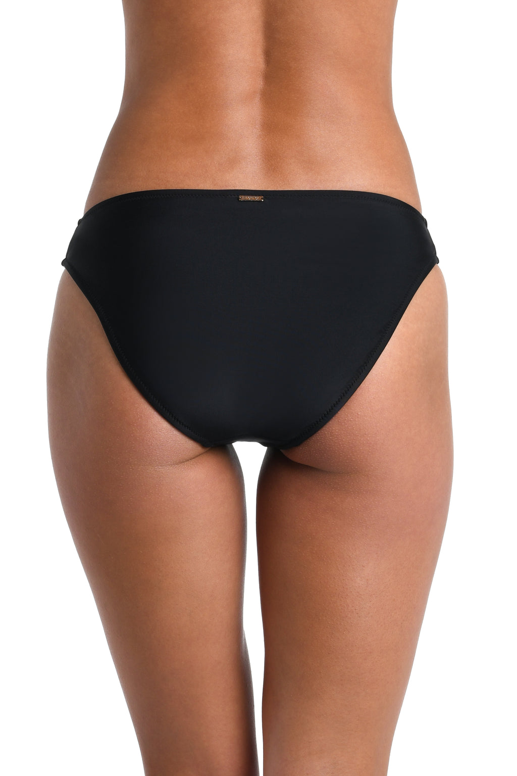 Black bikini bottom worn by a person on a white background