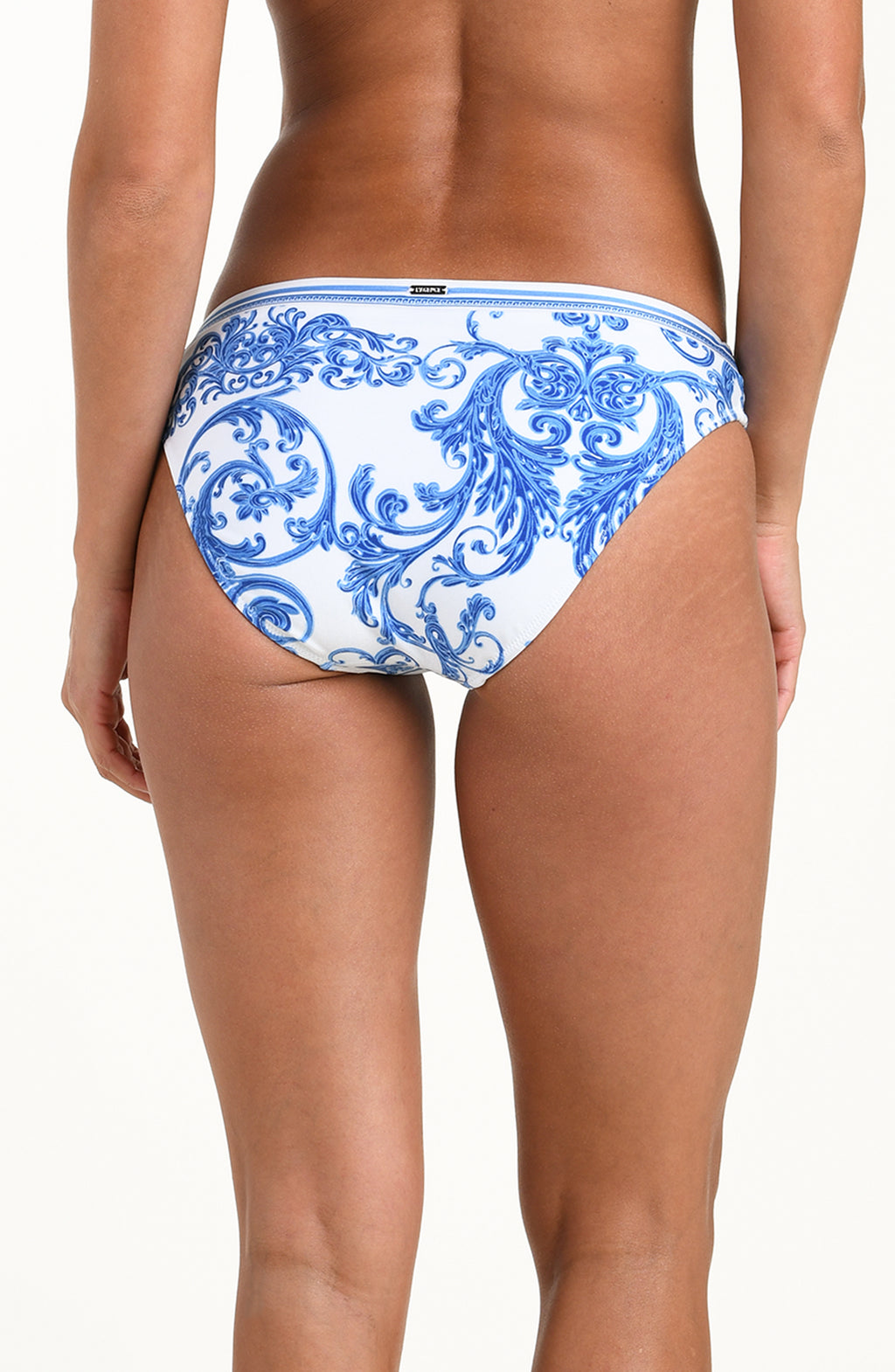 Woman wearing a white and blue bikini bottom against a white background.