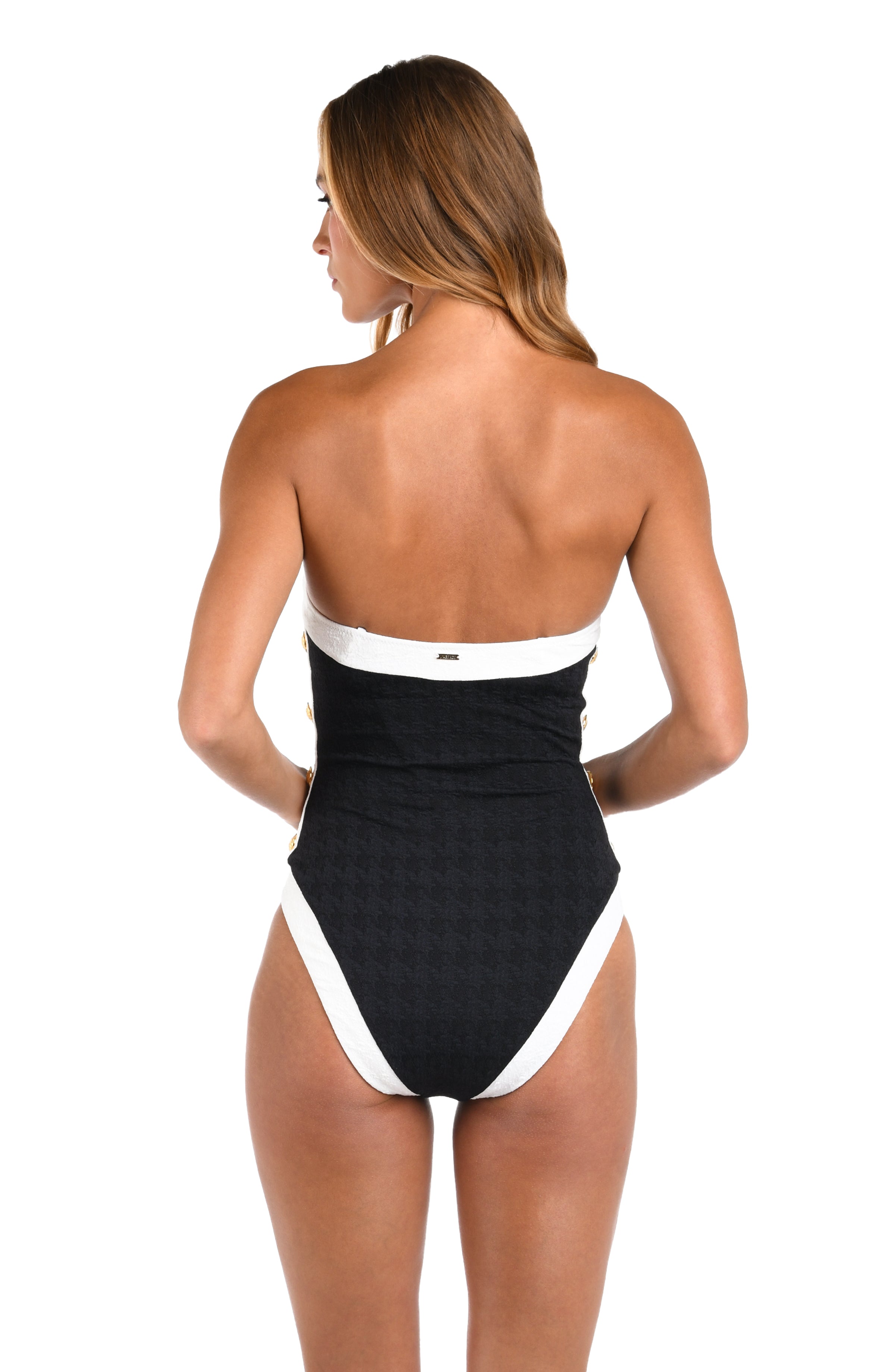 Woman wearing a black and white strapless swimsuit on a white background