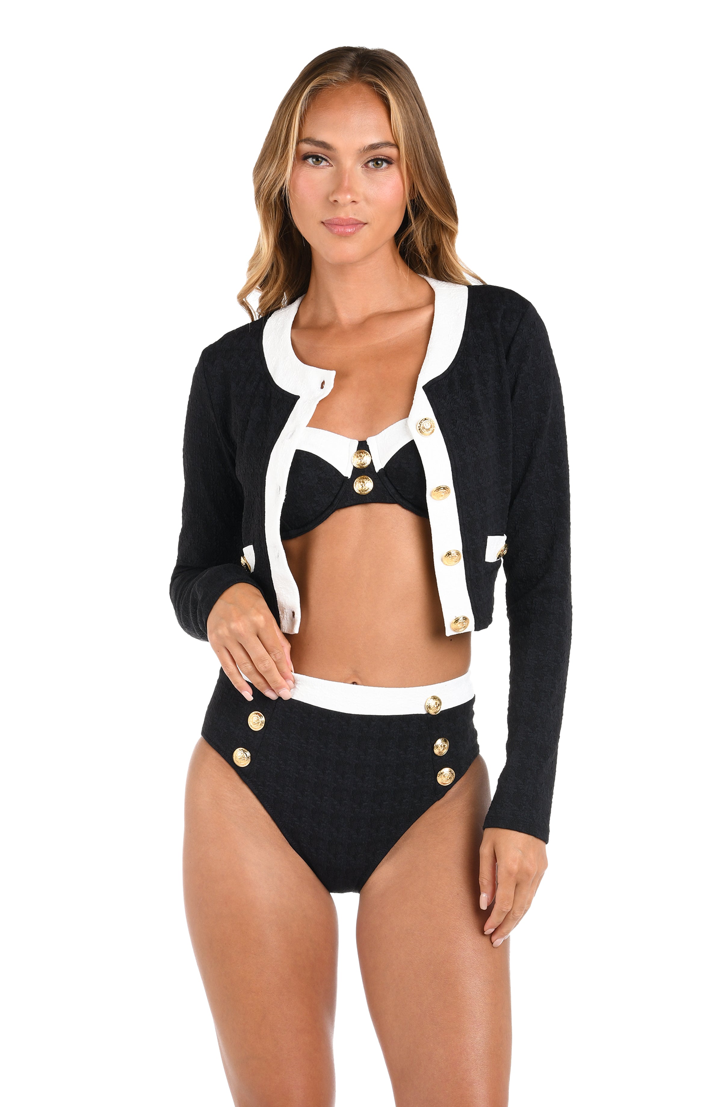 Woman wearing a black and white bikini with a matching cardigan on a white background
