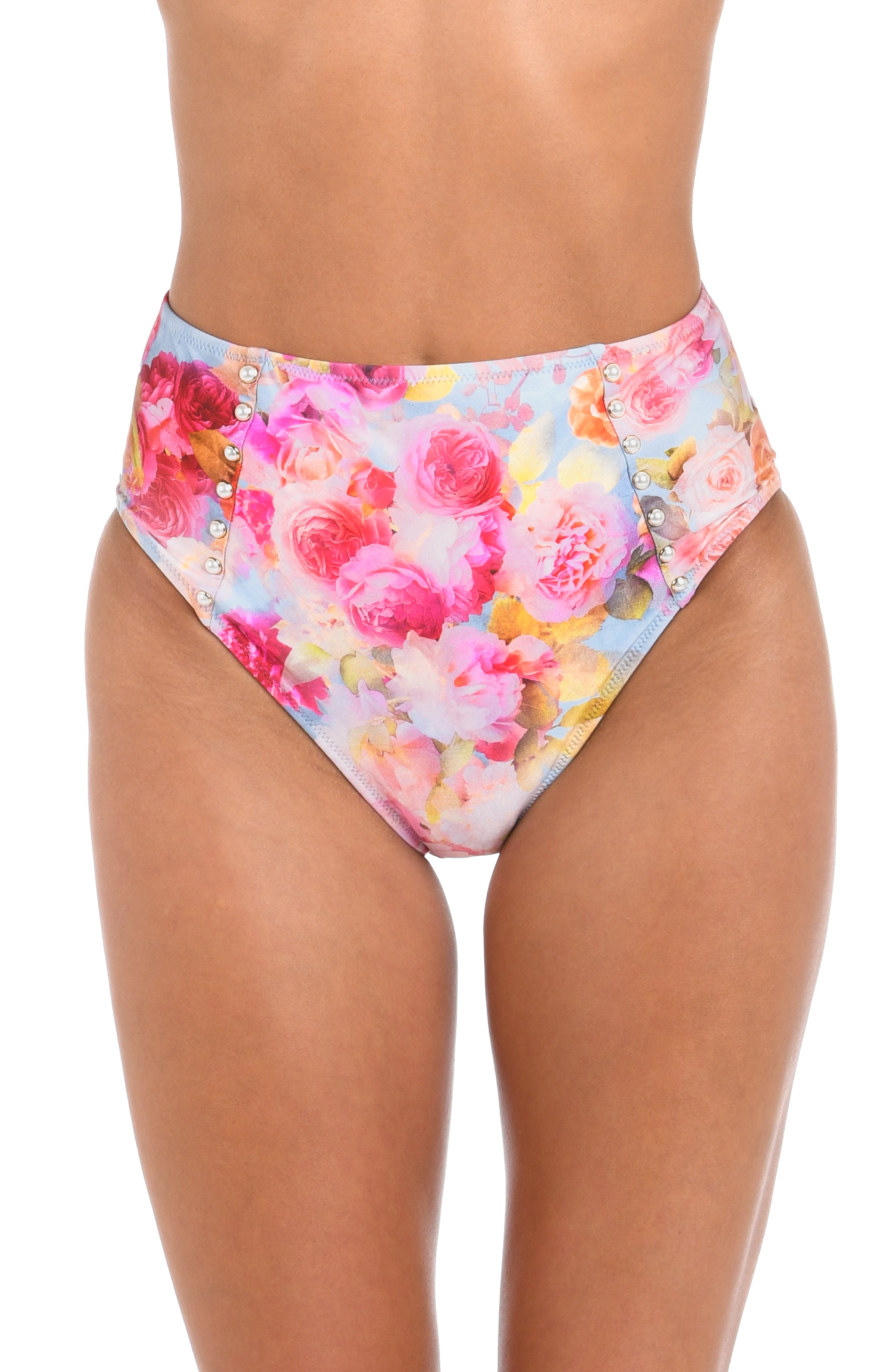 Woman wearing a light multicolored floral printed high waisted bikini bottom against a white background. 