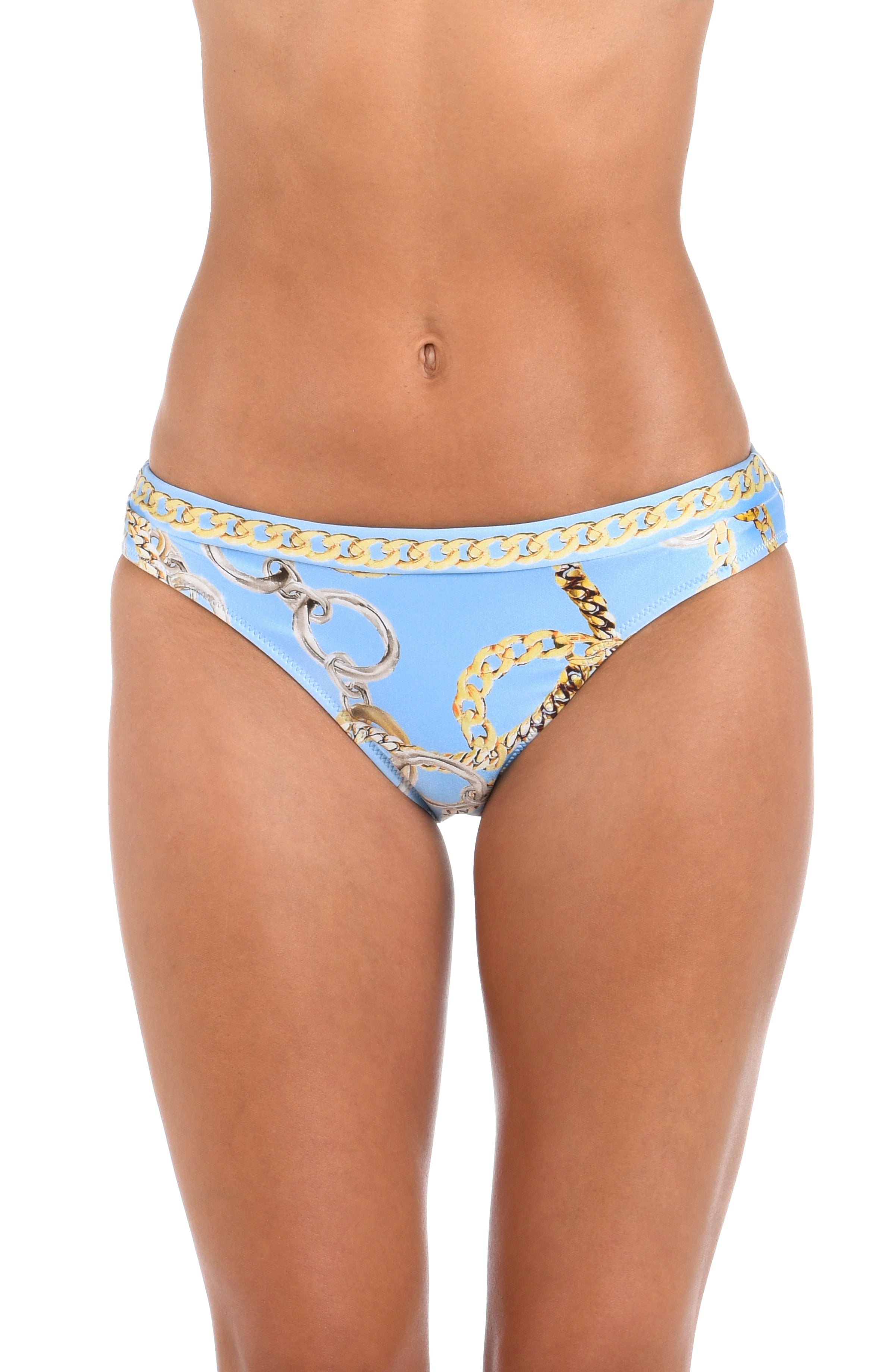 A woman wearing light blue bikini bottoms with a gold chain print and a bow detail on the front, set against a plain white background.