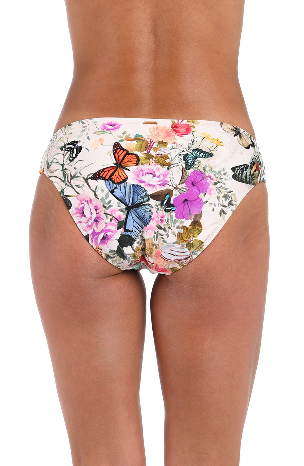 Rear view of a model wearing bikini bottoms with a colorful butterfly and floral print on a white base, shown against a plain white background.