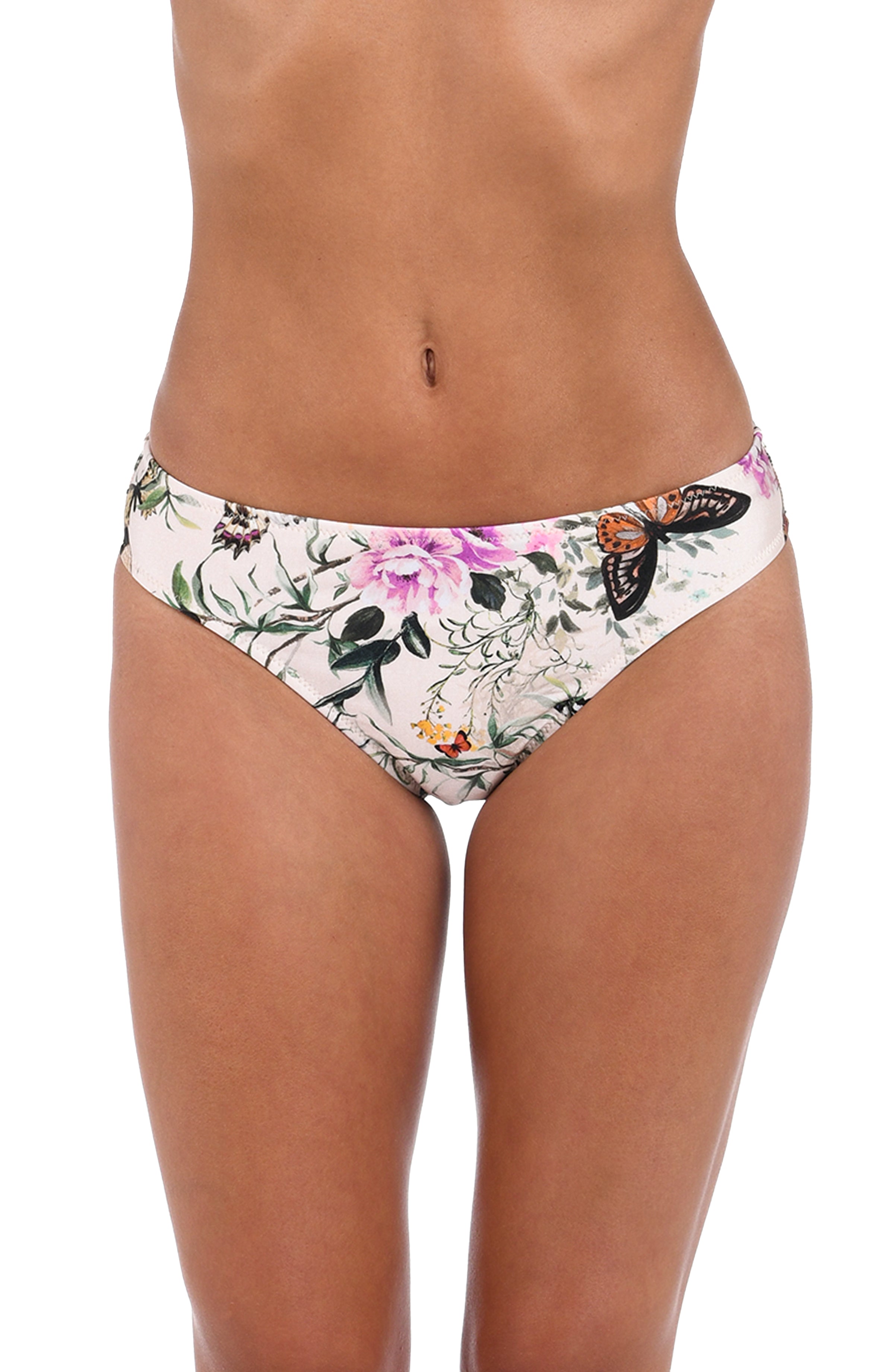 A close-up of a model's lower torso wearing bikini bottoms with a white base and a colorful floral and butterfly print.