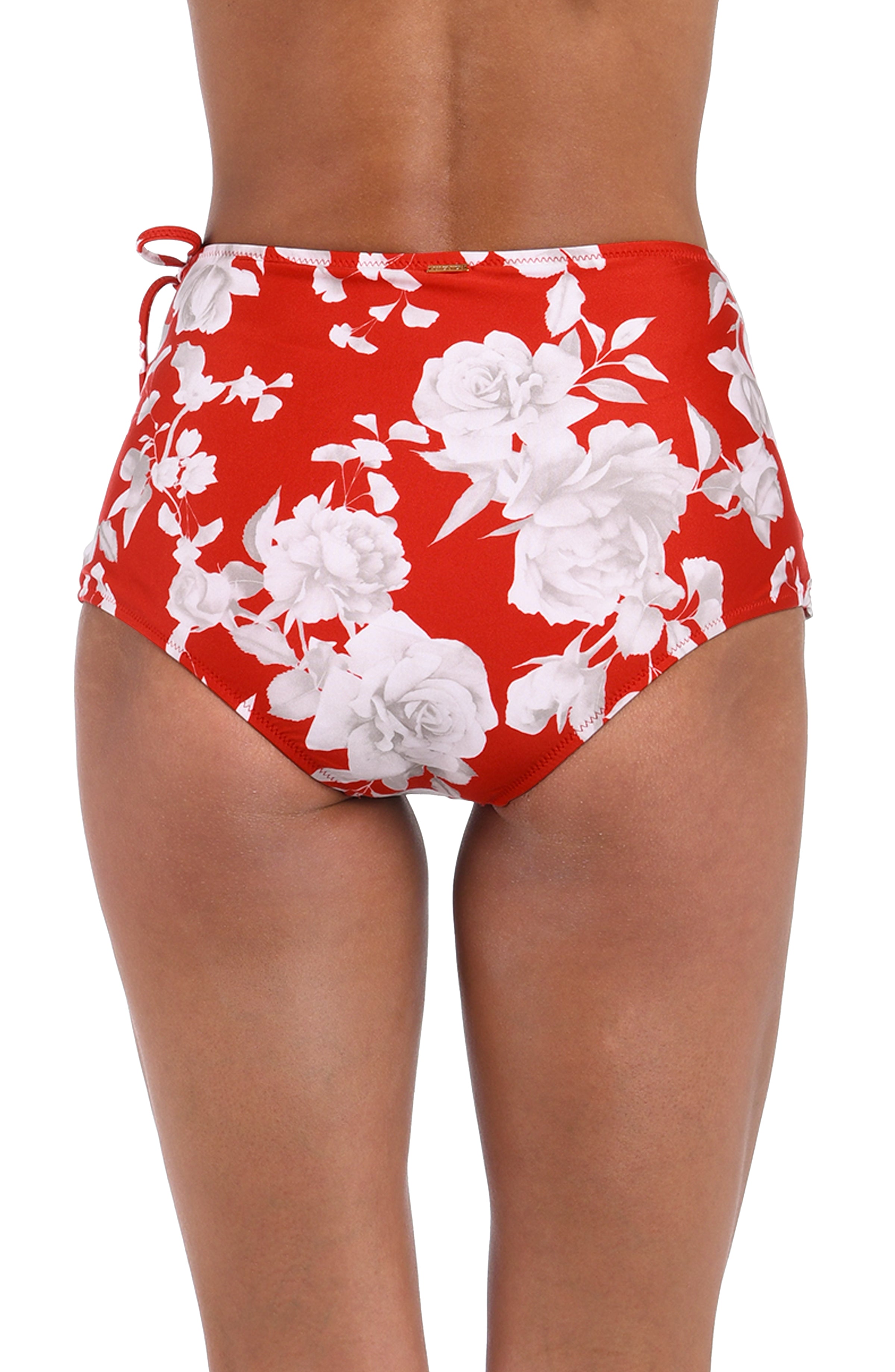 Red and white floral print swim skirt shown on a model, featuring a side tie detail on the right hip.