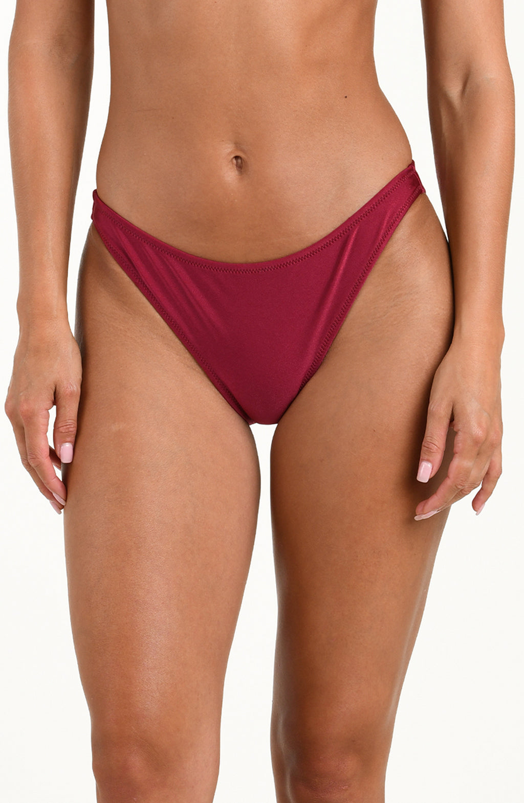 Woman wearing a black cherry bikini bottom against a white background.