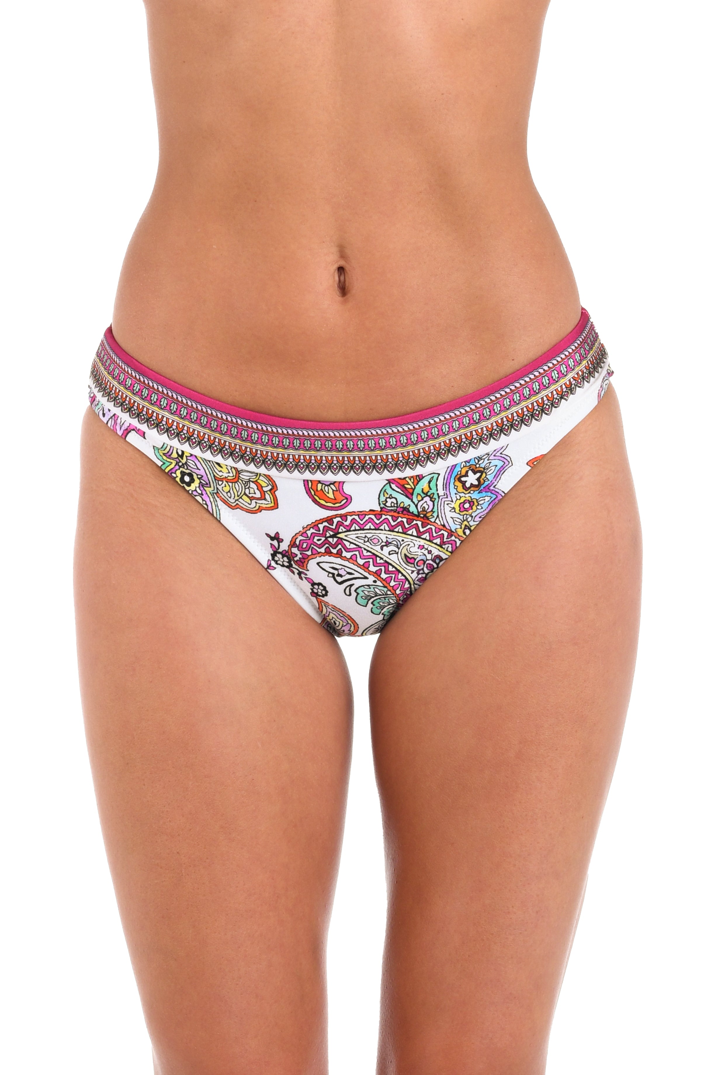 A woman wearing bikini bottoms with a white base, colorful paisley print, and a pink and multicolor patterned waistband.