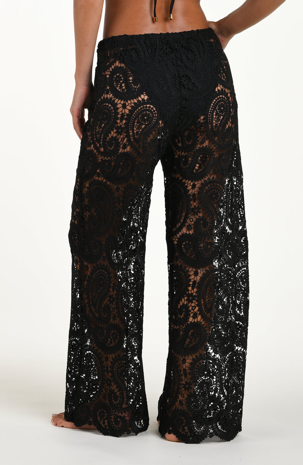 Black lace pants worn by a person on a white background