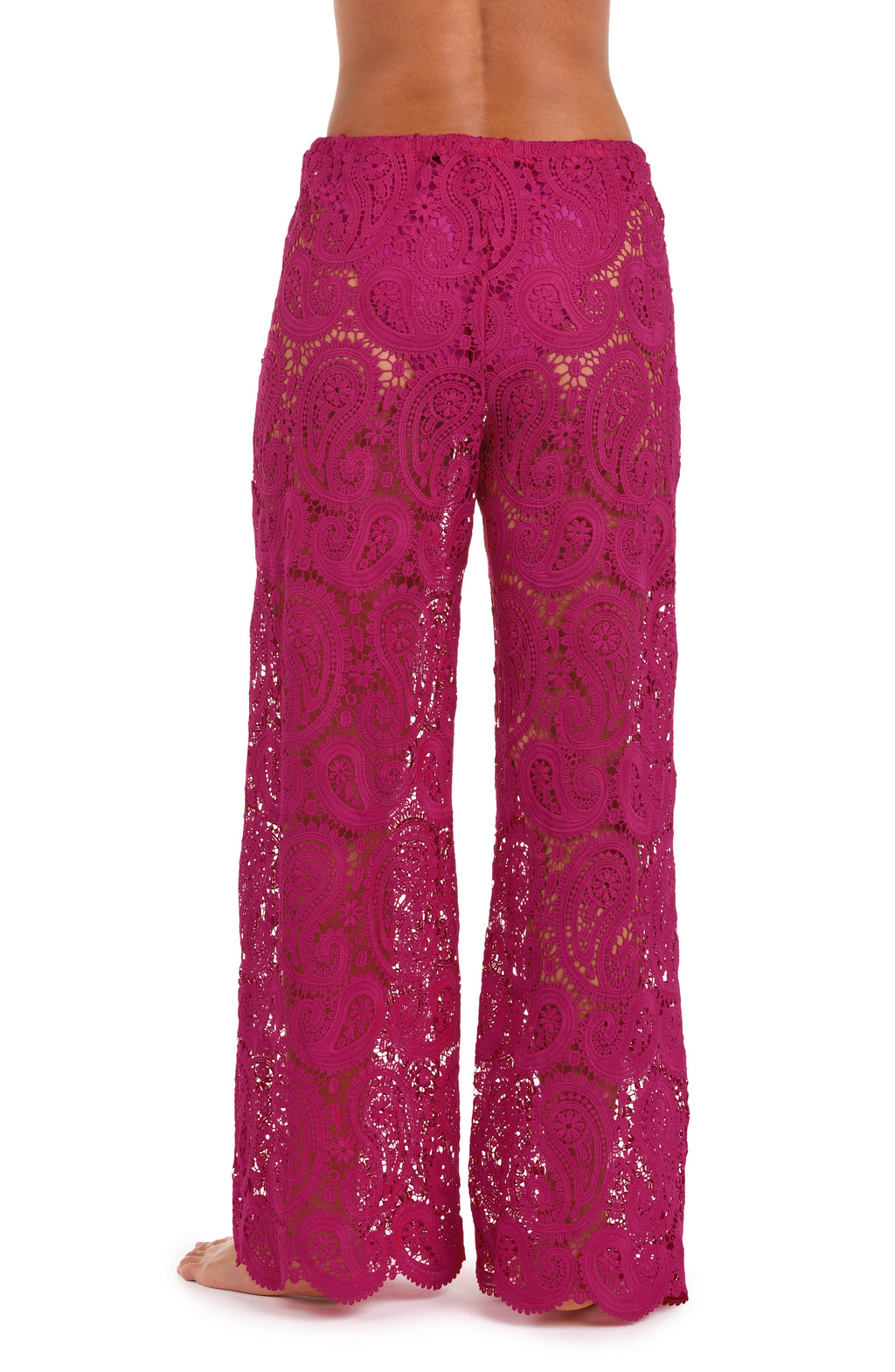 A person wearing bright fuchsia lace wide-leg pants with a drawstring waist against a white background.