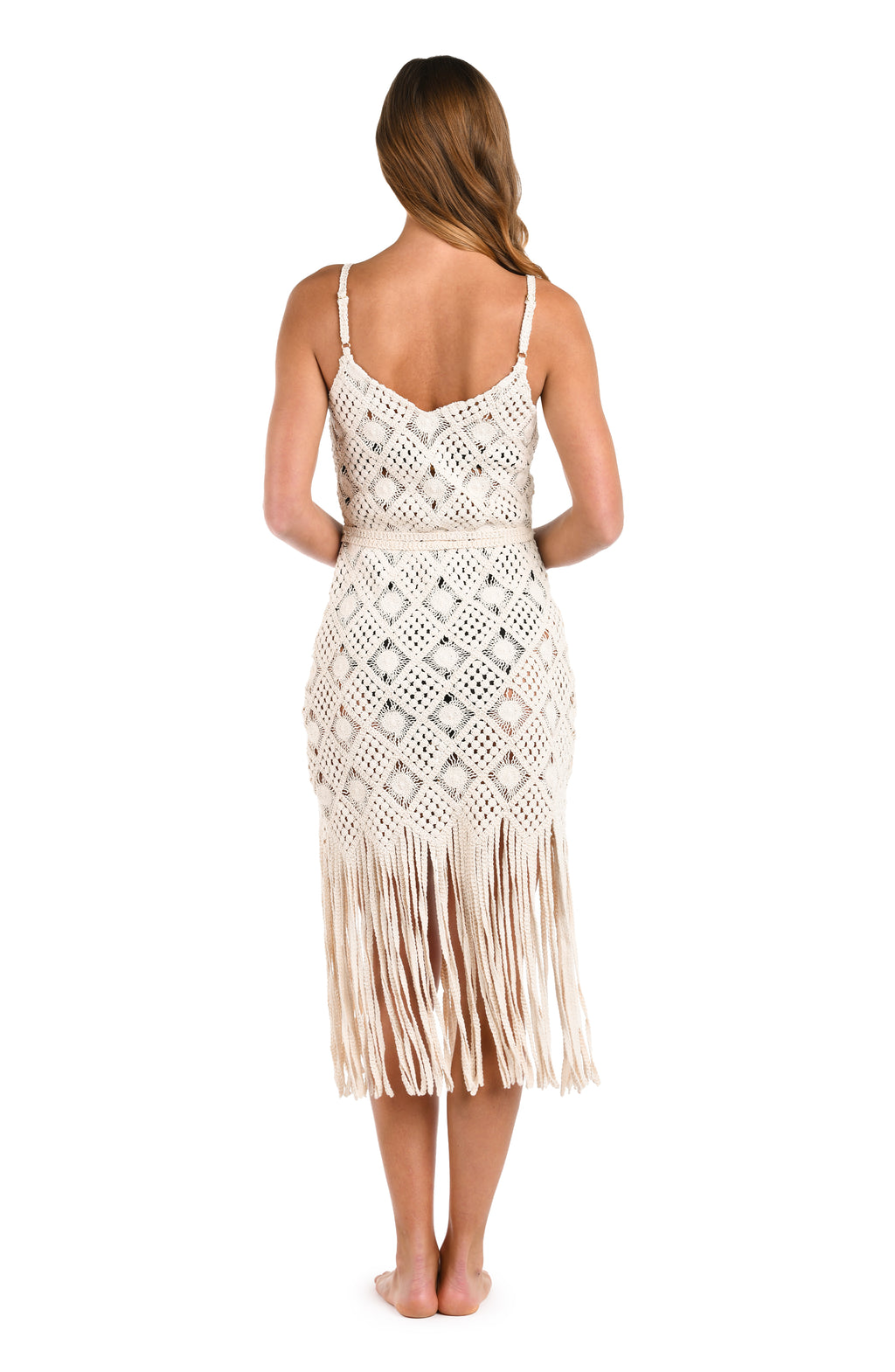 Woman wearing an ivory crochet dress against a white background. 