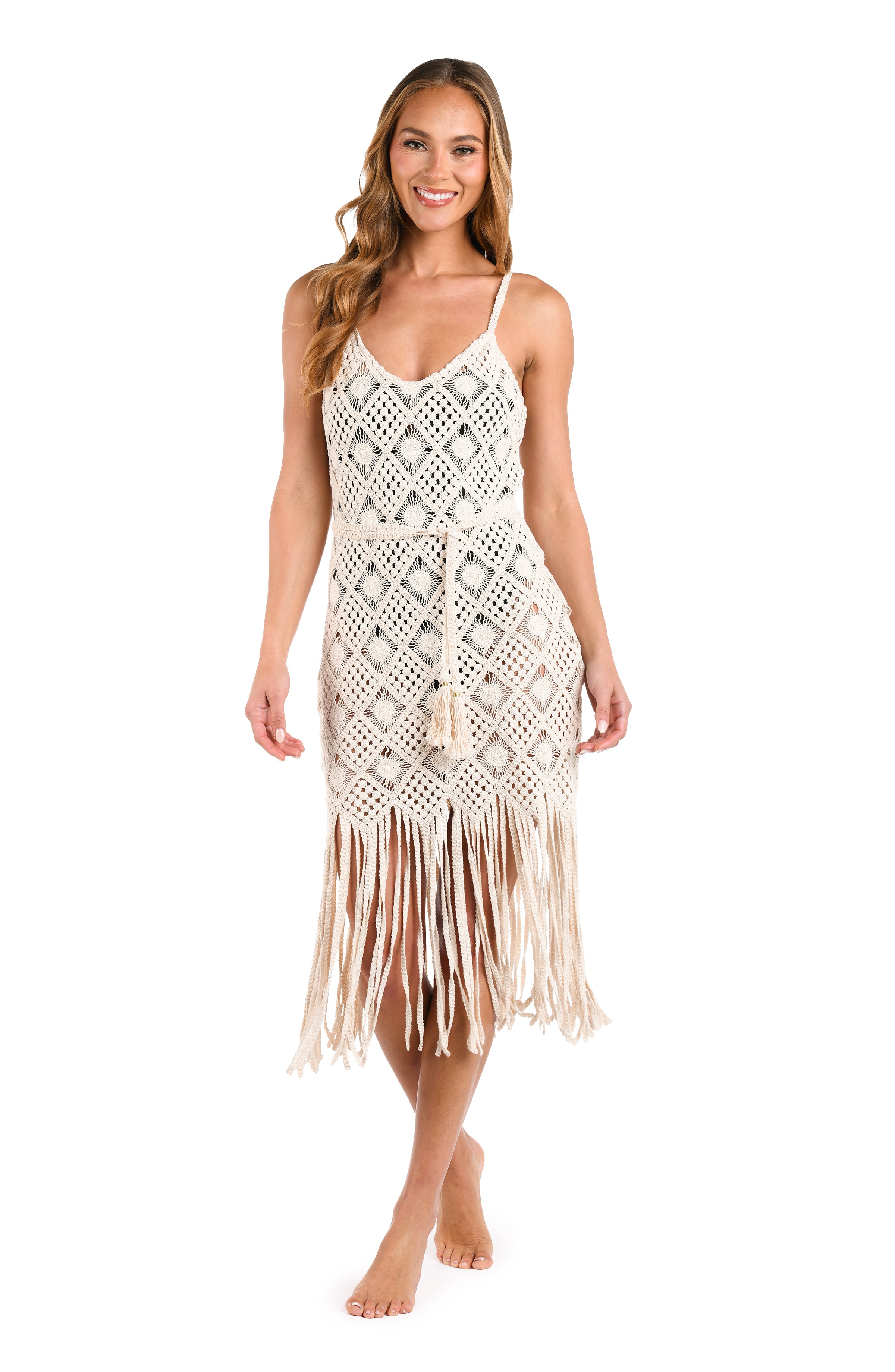 Woman wearing an ivory crochet dress against a white background. 