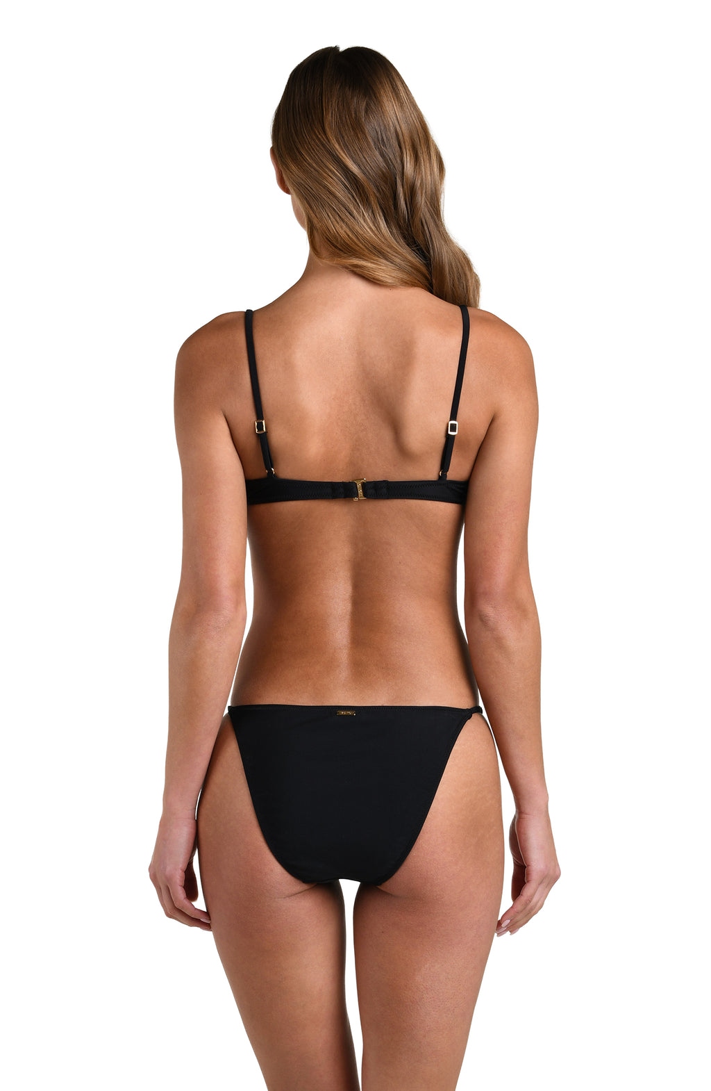 A woman wearing a solid black bikini top and matching bikini bottom against a white background. 