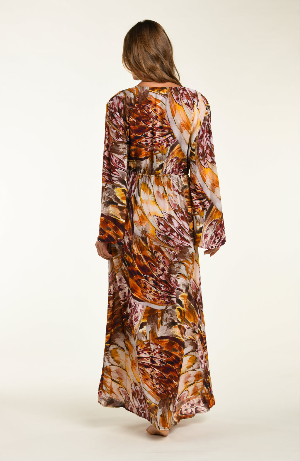 Woman wearing a long, patterned robe on a white background