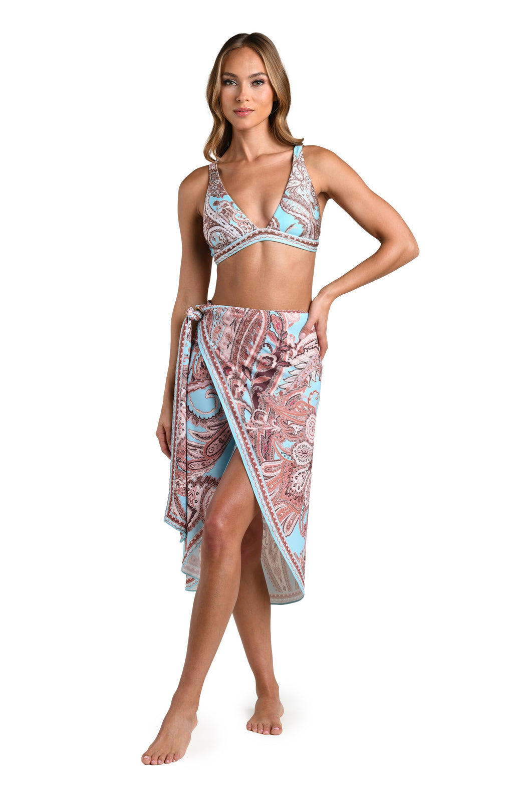 Woman wearing a multicolored sarong cover up and a matching bikini top against a white background.