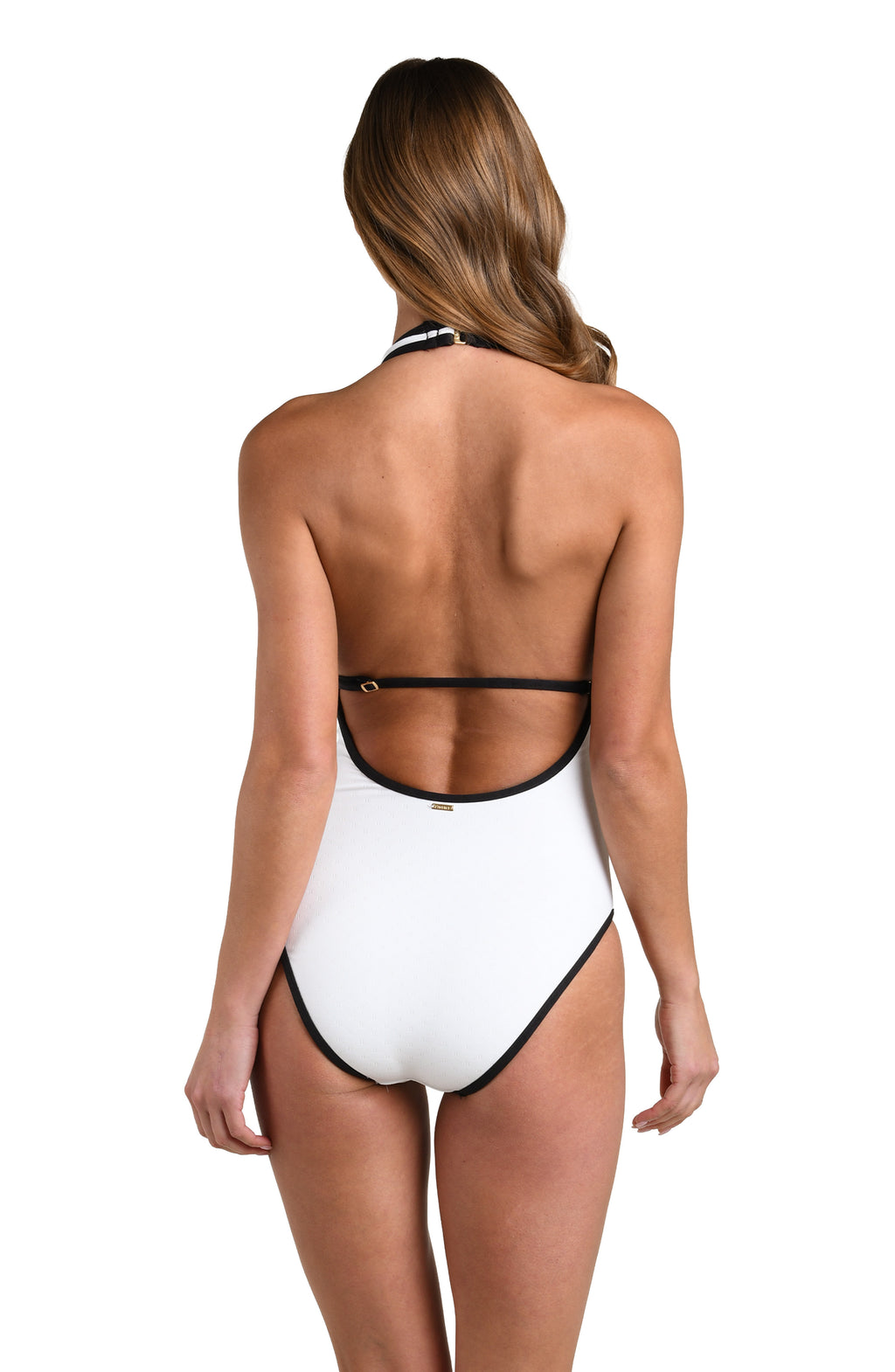 Woman wearing a white one piece swimsuit with black trim on a plain background