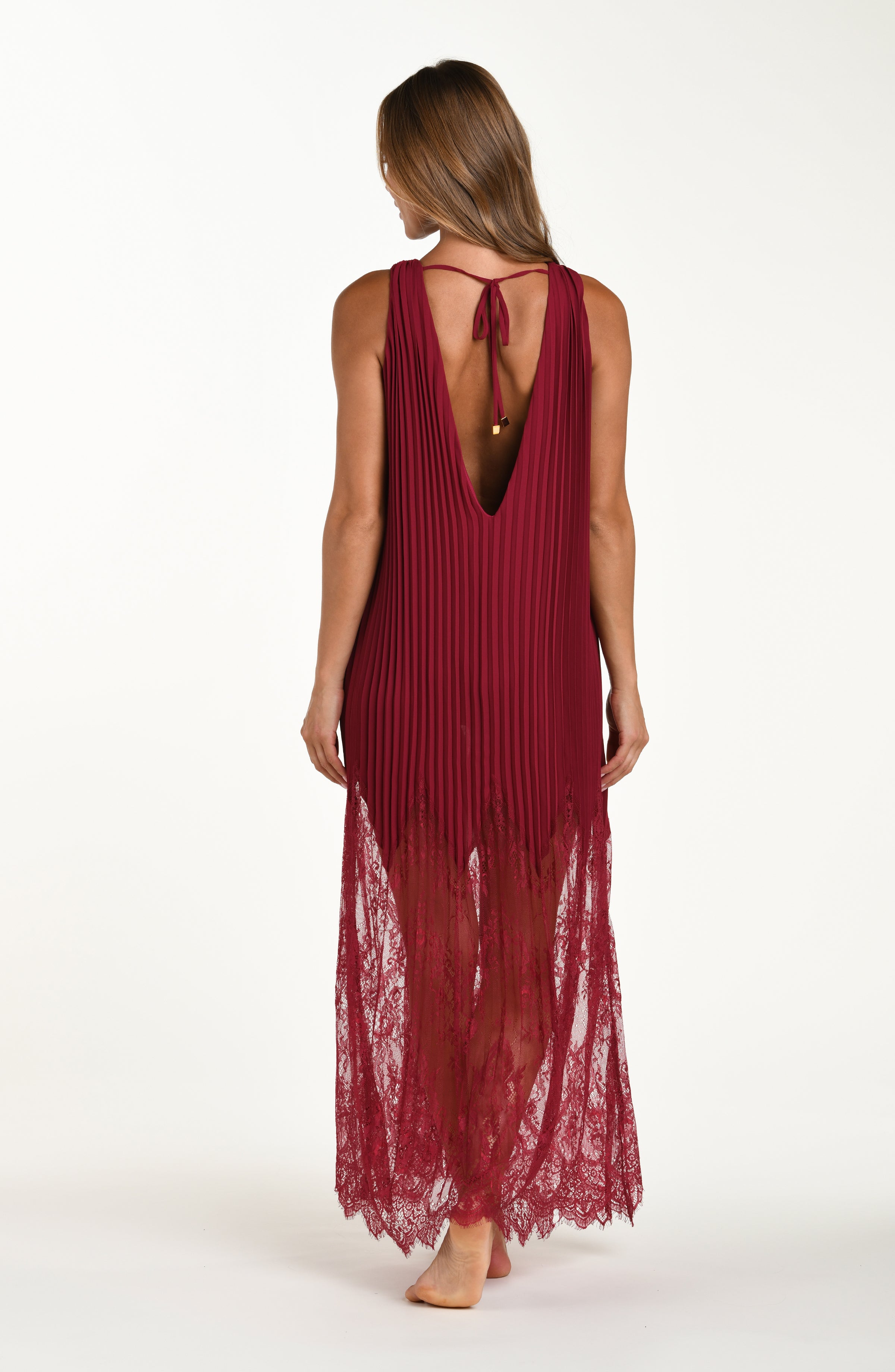 Woman wearing a dark cherry maxi dress against a white background. 