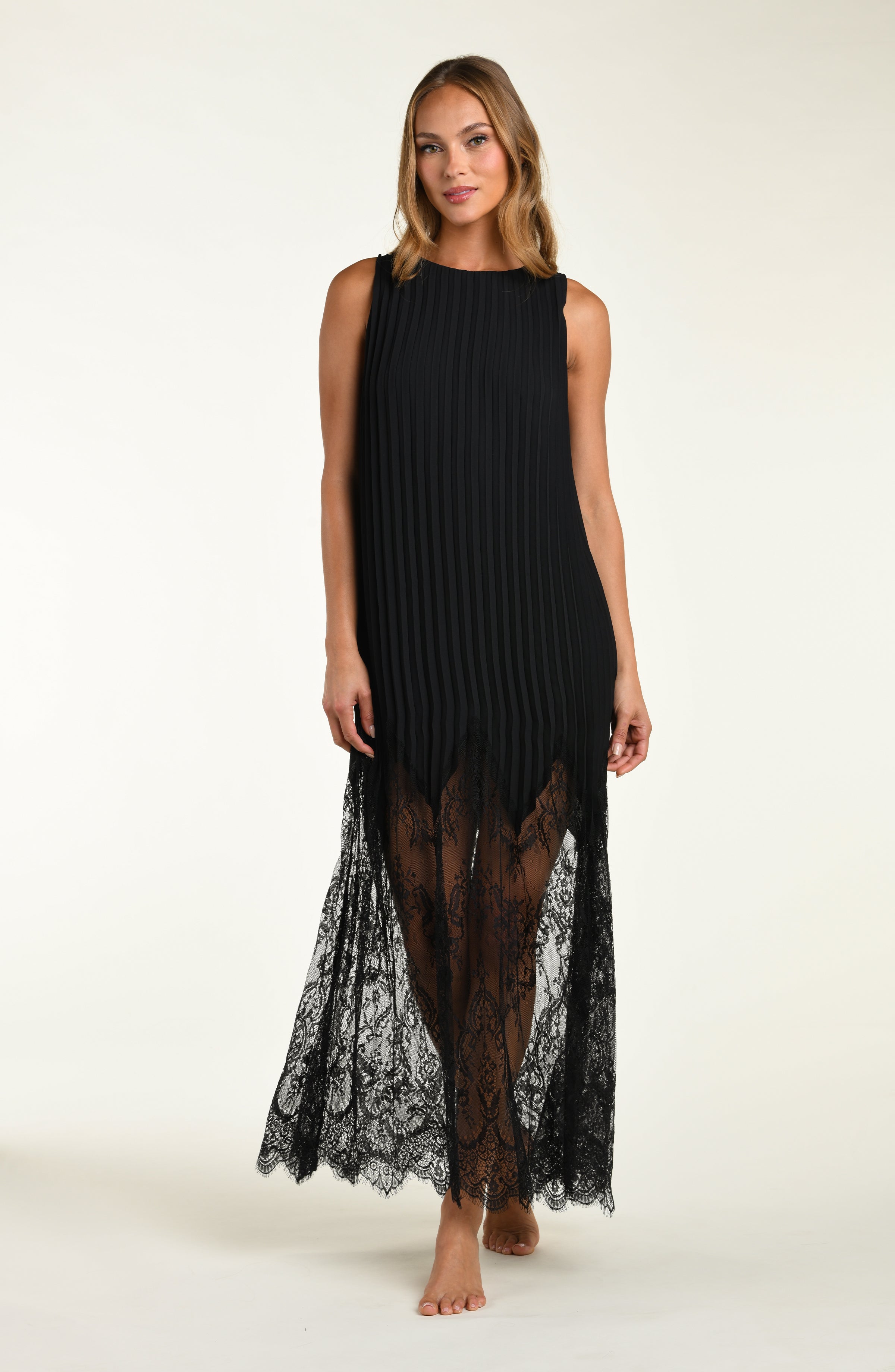 Woman wearing a black sleeveless dress with lace detailing on a white background