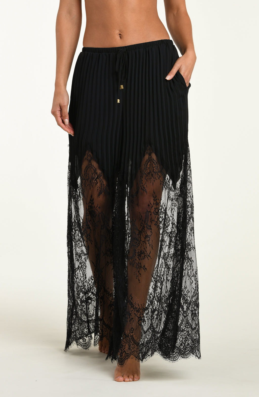 Black lace pants worn by a person on a white background