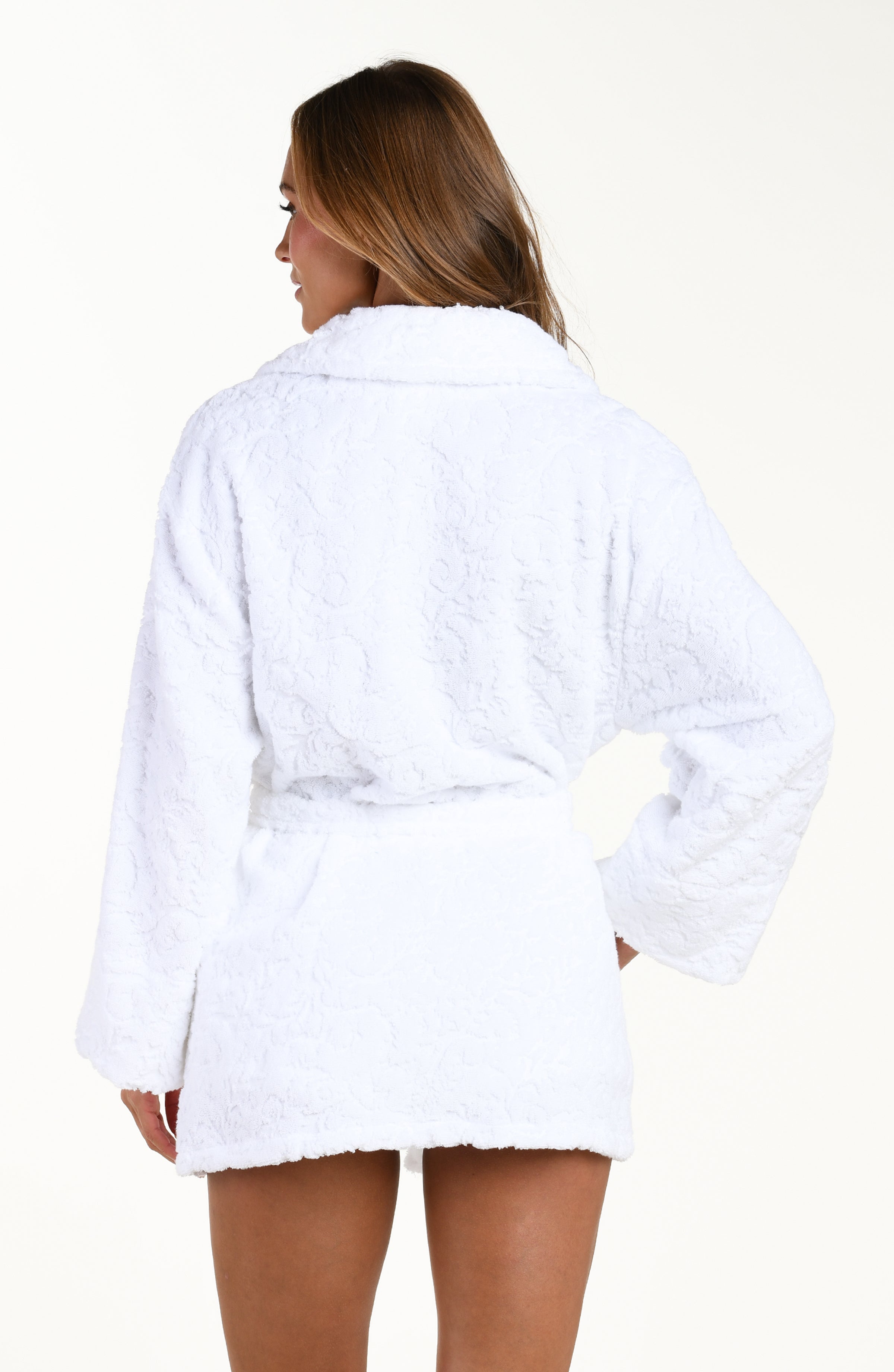 Back image of model wearing solid white jacquard kimono robe featuring a clean back, removable belt, front pockets, long sleeves, and side pockets.