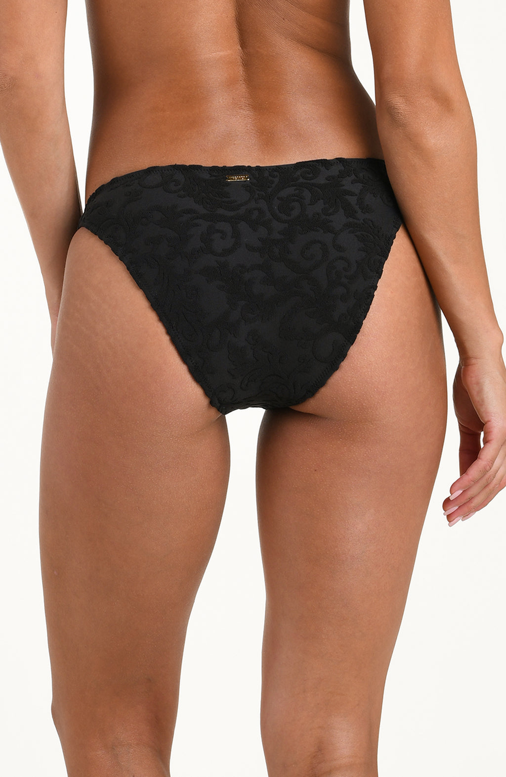 Back image of model wearing a black jacquard bikini bottom featuring a mid-rise fit, scoop front, high leg, gold logo hardware on one side, and contemporary rear coverage.